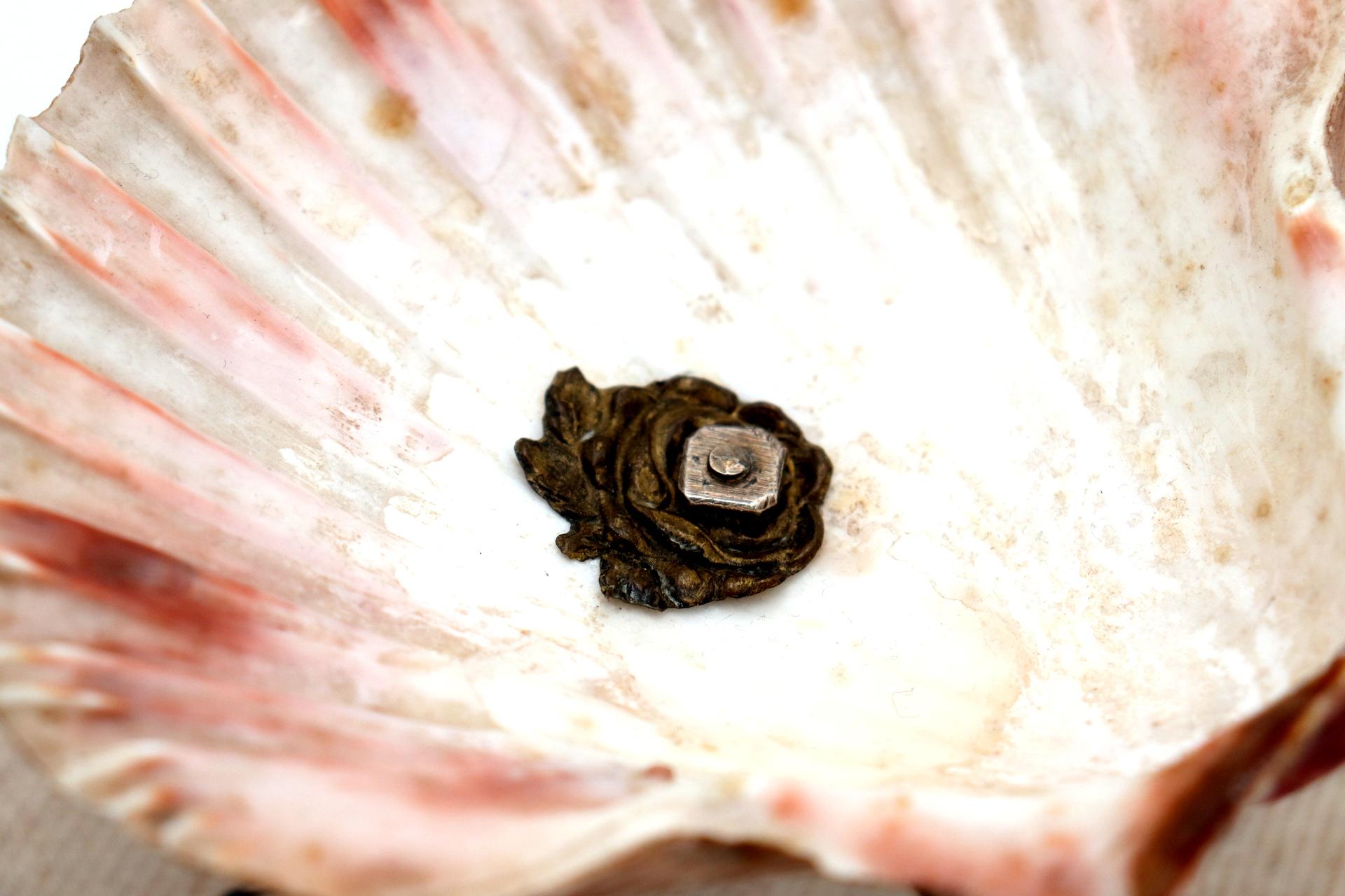 Description; Half-shell shaped ashtray with silver structure and leaf applications on the feet. Metal: Silver. Origin: Portuguese. Brand: javali II Title. Weight: 123.17 grams. Dimensions: 11.5cmx10cm. Content: 833/1000. Assay Mark: Yes, between