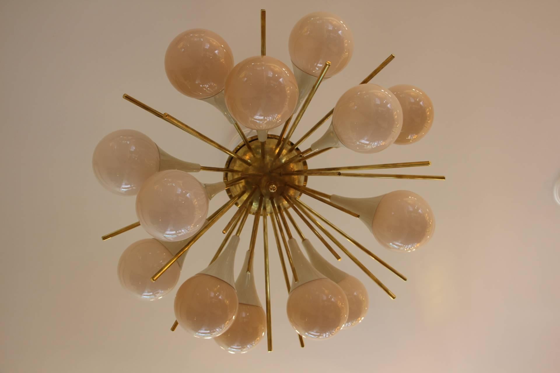 This fabulous chandelier features 15 pinkish-beige Murano glass globes and 15 brass stems.
It looks like large flowers and is really breath taking.
When light is on, its very light pink-beige globes turn to beige color.
All globes are not exactly