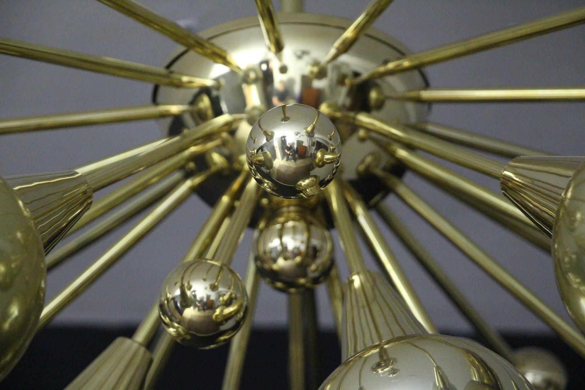 This brass chandelier features 15 hand blown golden murano glass globes and 15 brass balls extends on brass stems from its centre.
When the light is on, globes change color and become mercurised at the bottom and clear on the top.
Unusual
