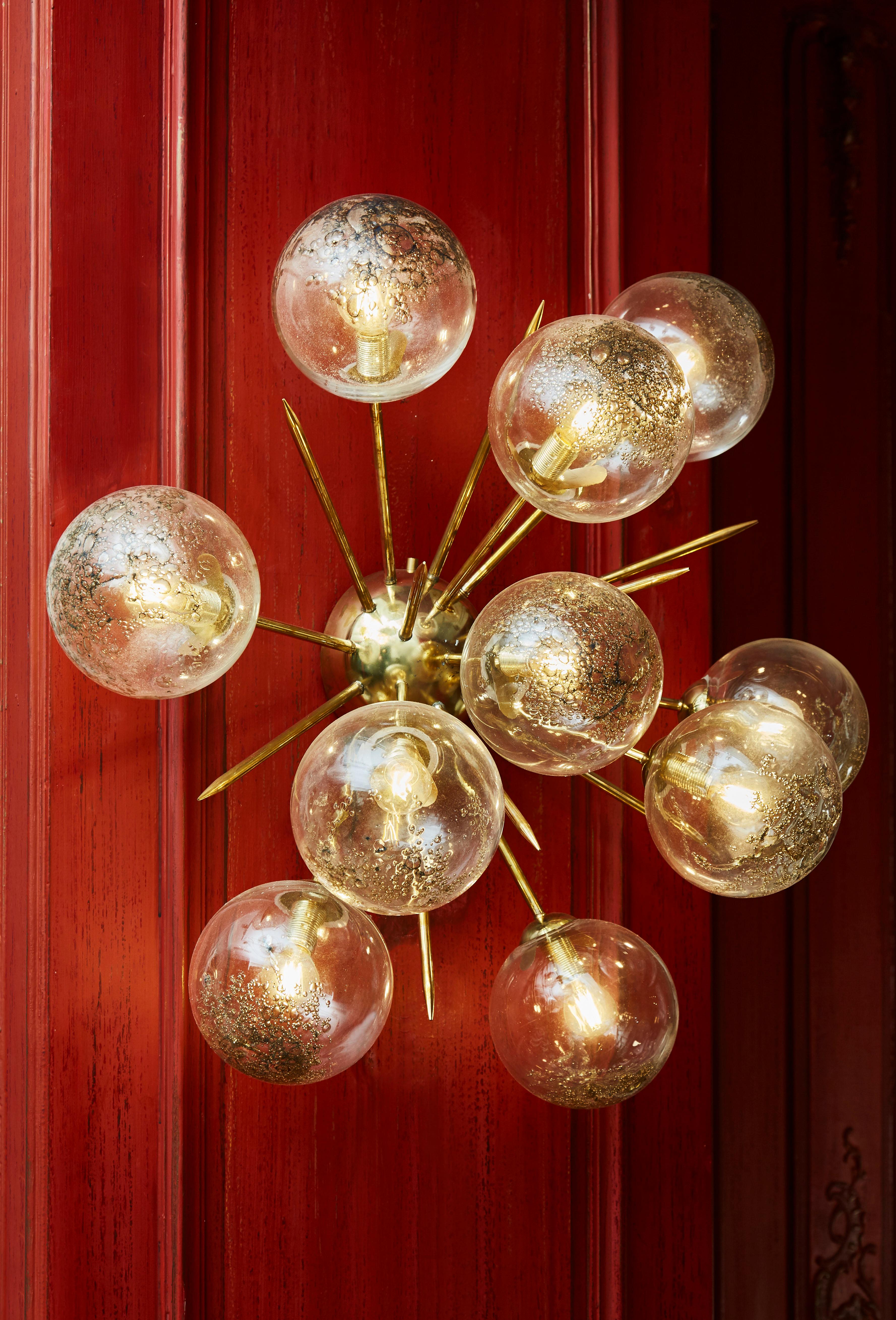 Wunderschönes Paar halber Sputnik-Leuchten aus Messing und Kugeln aus geblasenem Murano-Glas. 
10 Glühbirnen. Kann auch als Deckenleuchte verwendet werden. Gestaltung durch das Studio Glustin.