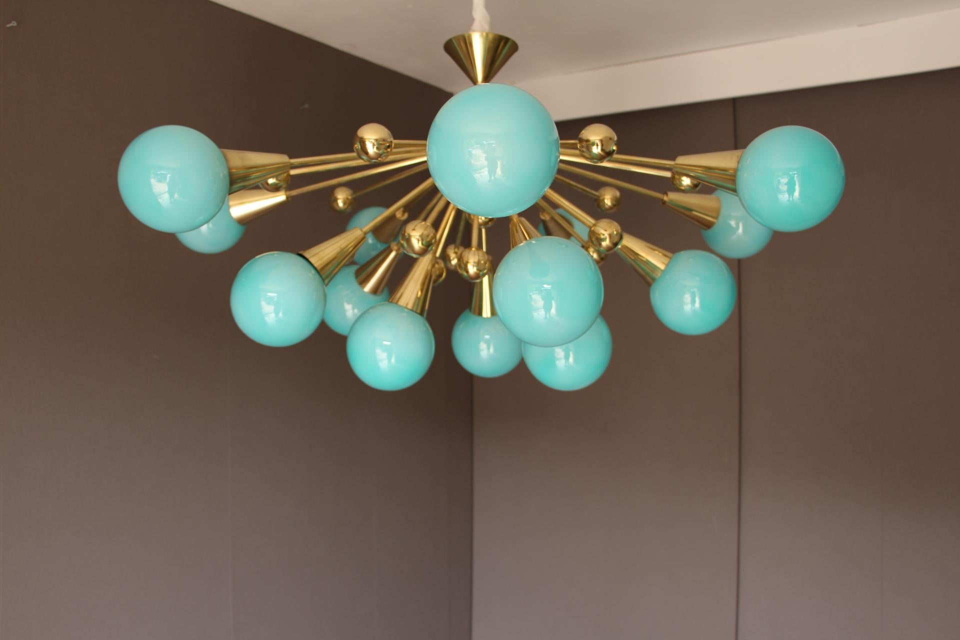 This spectacular brass chandelier features 15 turquoise blue hand made Murano glass globes and 15 brass balls extends on brass stems from its center.Color of its globes is really attractive,it is a kind of Tiffany blue.
When light is on, its