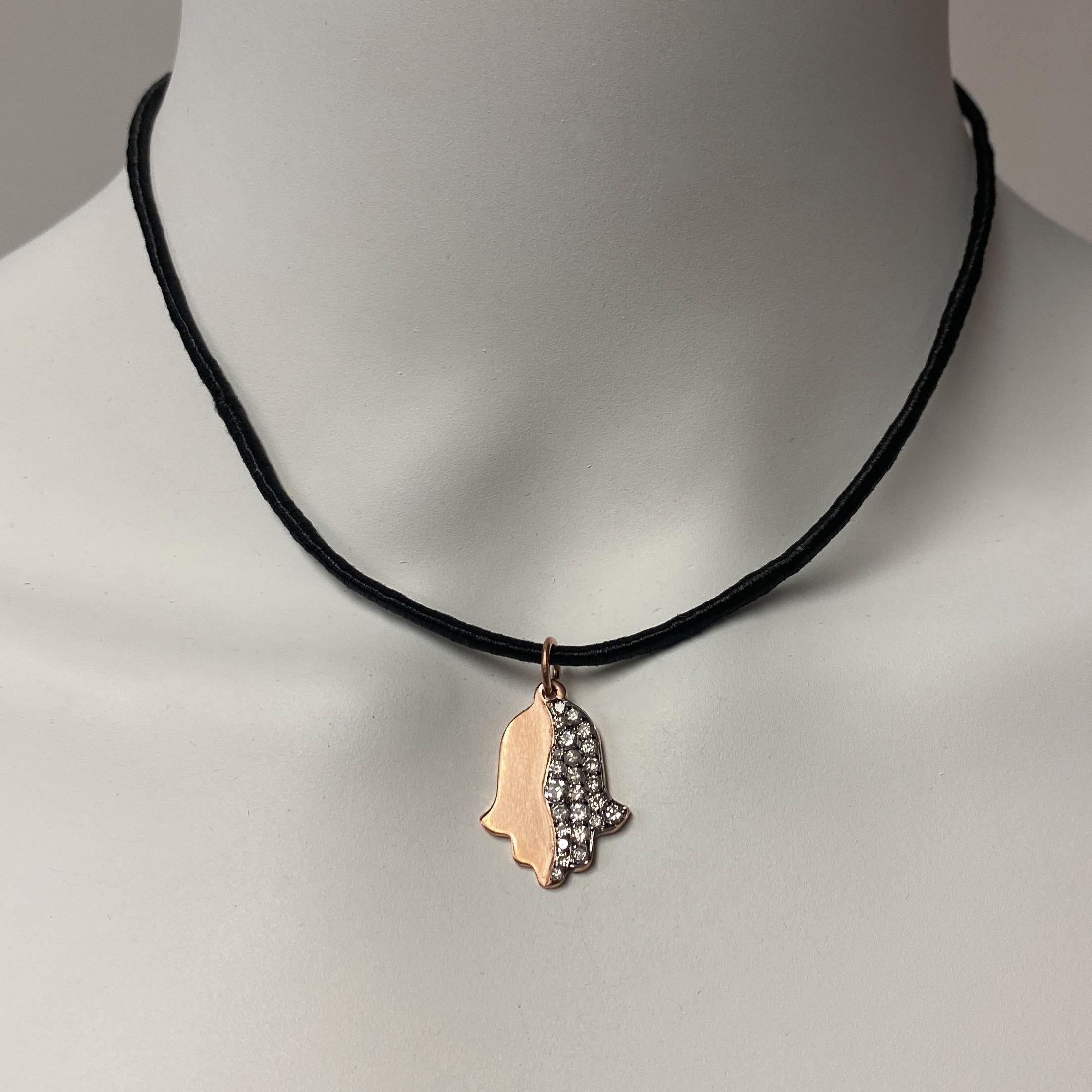 This cool little hamsa pendant by Eytan Brandes is satiny 14 karat rose gold, but its right half has been plated in black rhodium and set with 25 diamonds.

The diamonds range in size from about 1.5mm to 3mm and are all taken from Eytan's Big Box o'