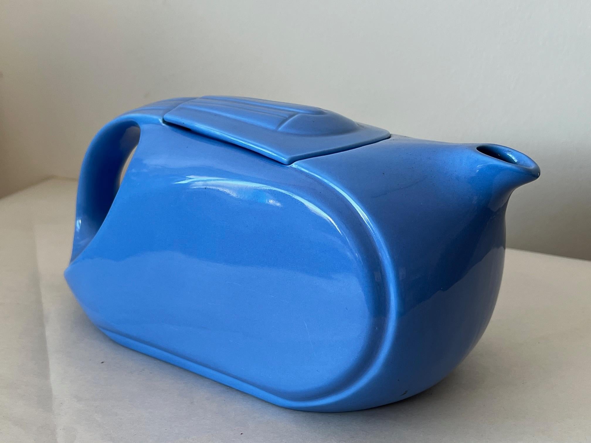 An Art Deco  Hall China blue glazed earthenware lidded refrigerator pitcher made for Westinghouse, which was a leading manufacturer of refrigerators in the 1930's. The pitcher is streamlined with elegant yet simple clean lines and is decorated in a
