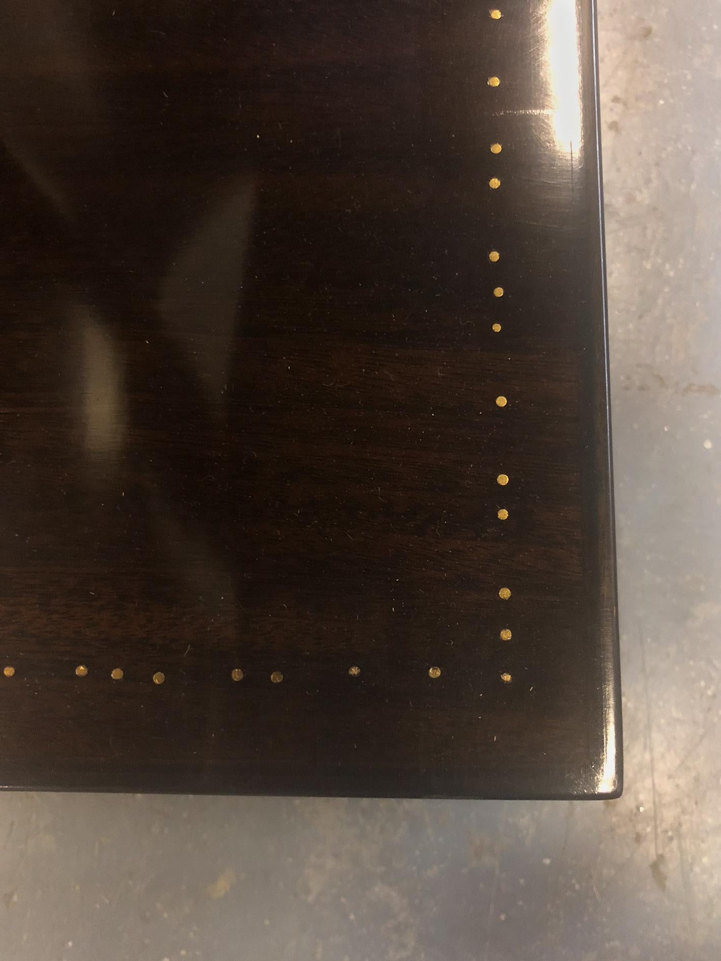 Acajou avec têtes de clous, renfermant une vitre en miroir d'origine avec quatre niveaux circulaires. Signé. Littérature : André Sornay de Roche, page 137 pour un modèle similaire. Largeur de la base : 44-1/4