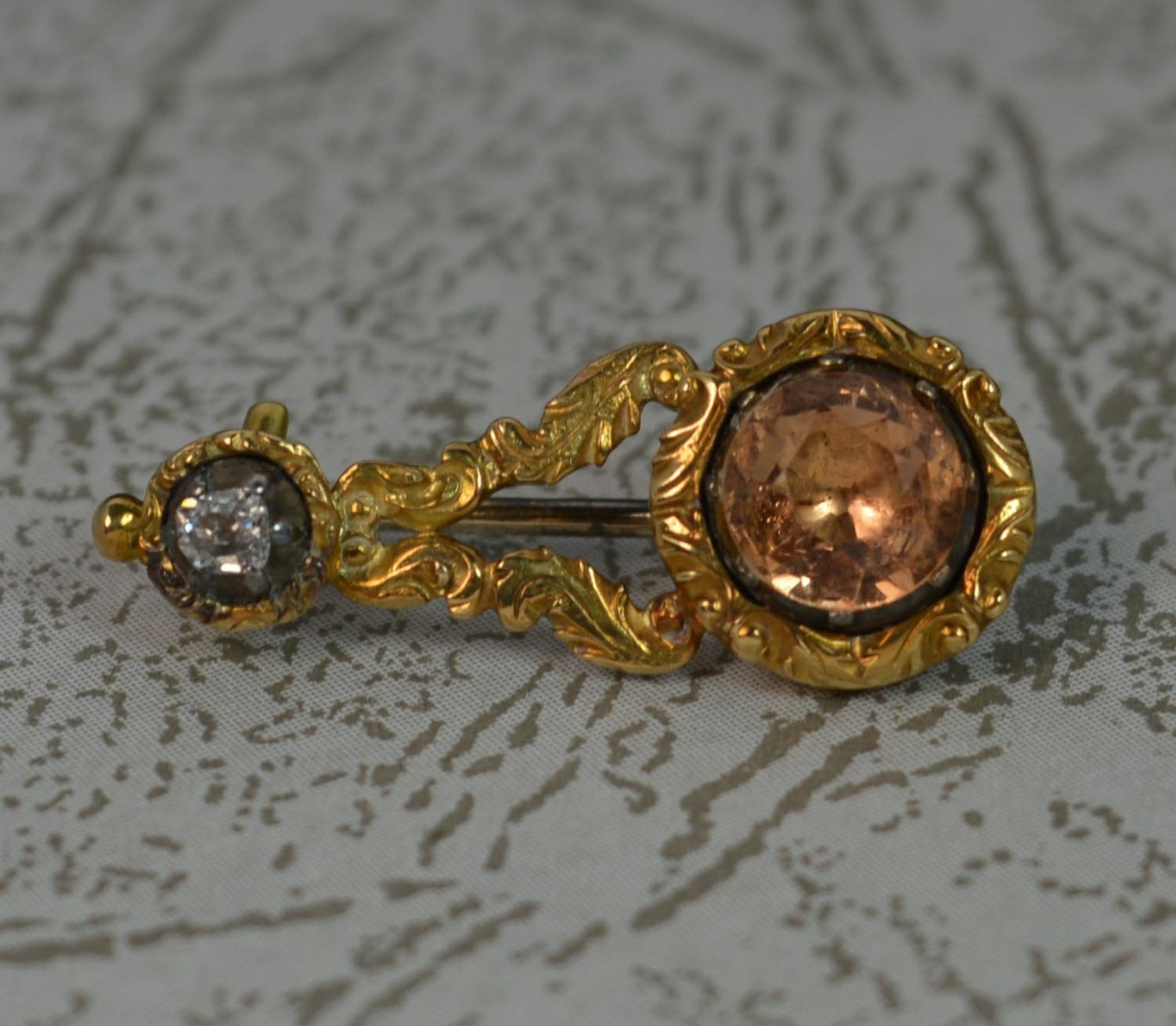 A stunning Georgian period brooch c1800. Halley's comet example. Solid 18 carat gold.
Designed with a circular closed foiled back topaz to one end and closed foil back old cut diamond the other. The centre with fine engraved floral