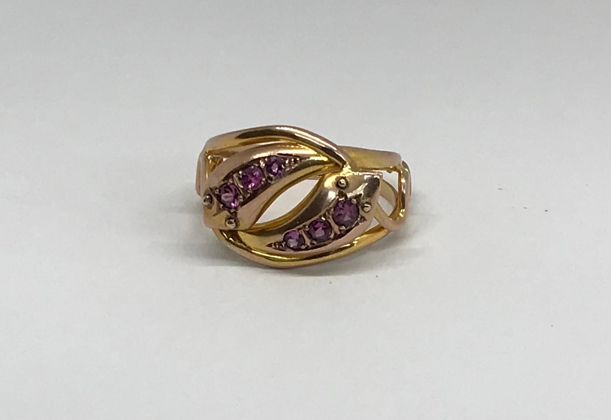 Substanzieller 9k Ring mit doppeltem Schlangenkopf, mit rosa Saphiren beladenen Spitzen, geschnitzten Goldaugen und einem modern aussehenden, durchbrochenen Goldband. Der Ring ist mit der Punzierung 