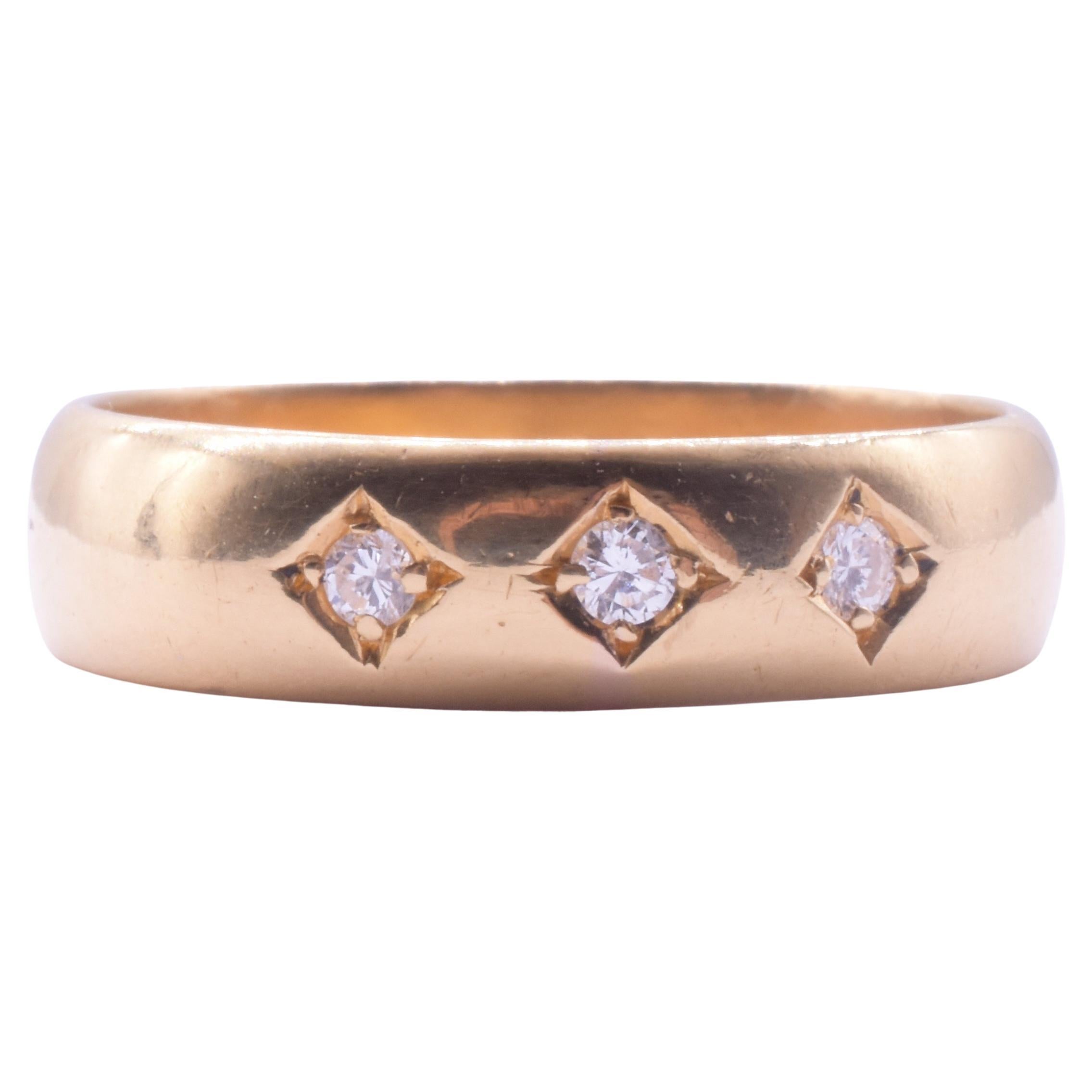 This modern streamlined 3 stone diamond gypsy band ring  is  is hallmarked for Birmingham, 1960 and is set in 22 carat. There is the initial 