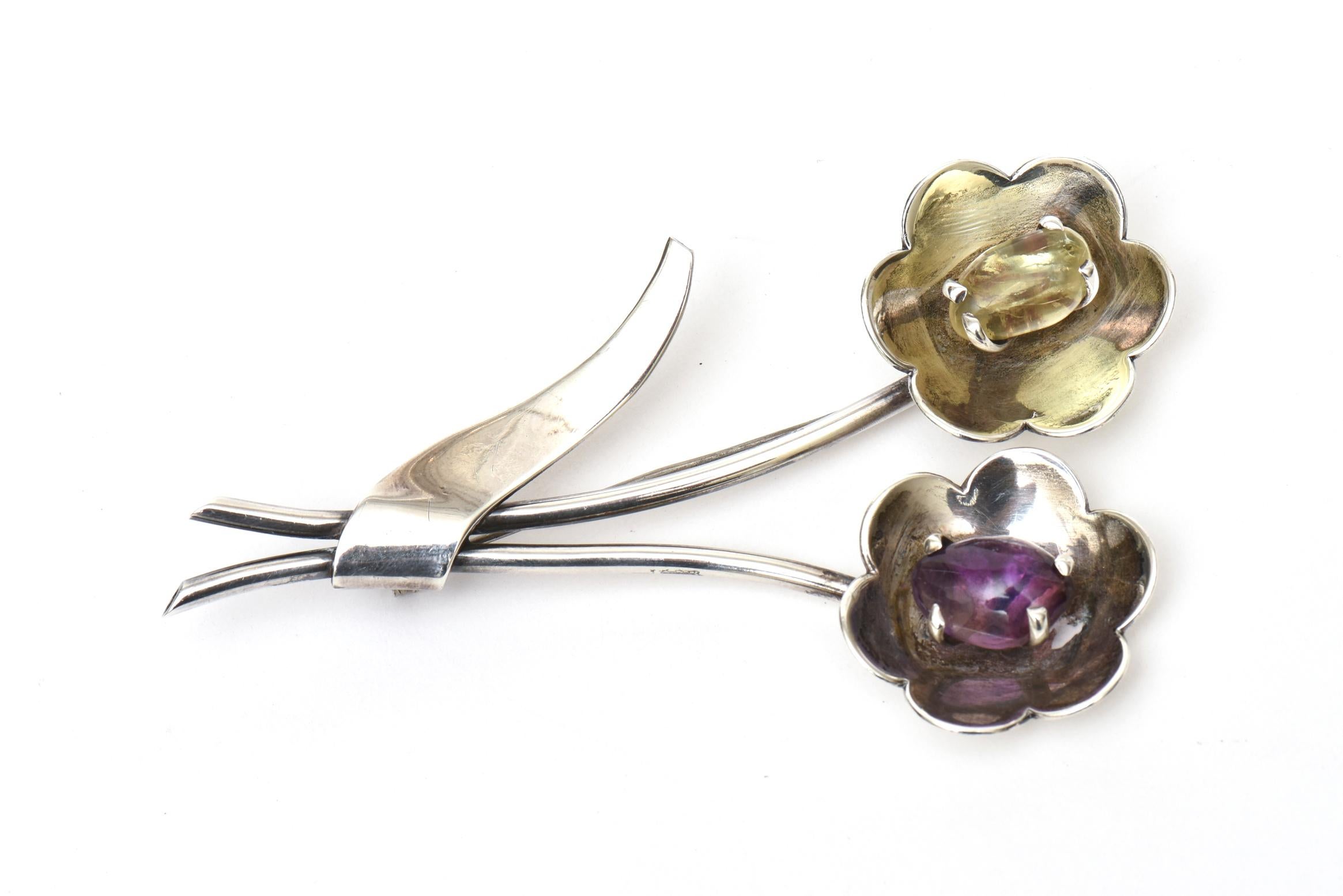 This lovely hallmarked flower pin or brooch is signed Sterling and AE. Most likely Mexican from the 70's. It is sterling silver, amethyst and citrine. The measurements are 4