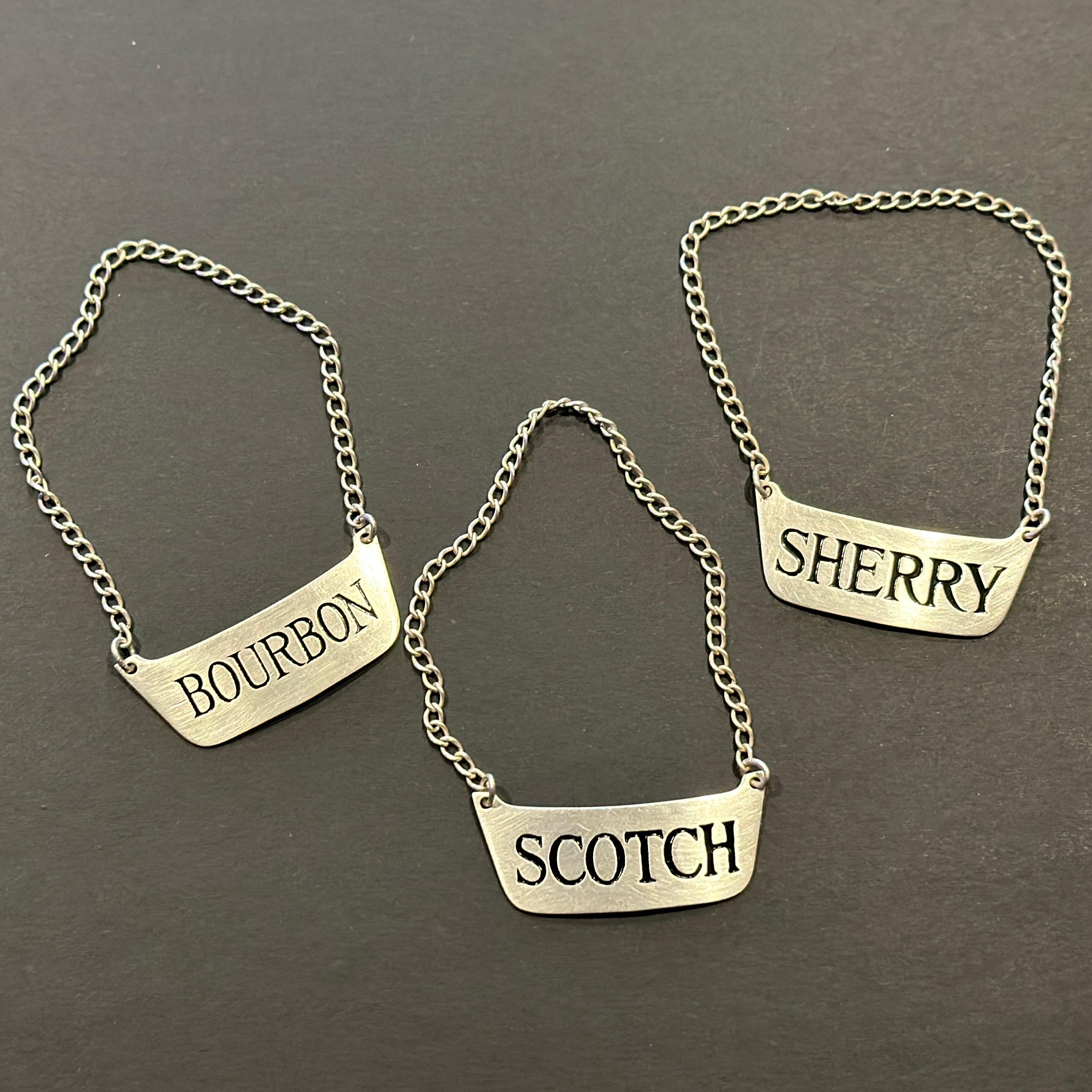 Targhette per bottiglie Bourbon Scotch Sherry Decanter in argento 925 con marchio di fabbrica - Set 3
Ciascuna è contrassegnata da un marchio di garanzia sopra la parola STERLING. Non siamo riusciti a leggere il marchio. Circa metà-inizio del XX