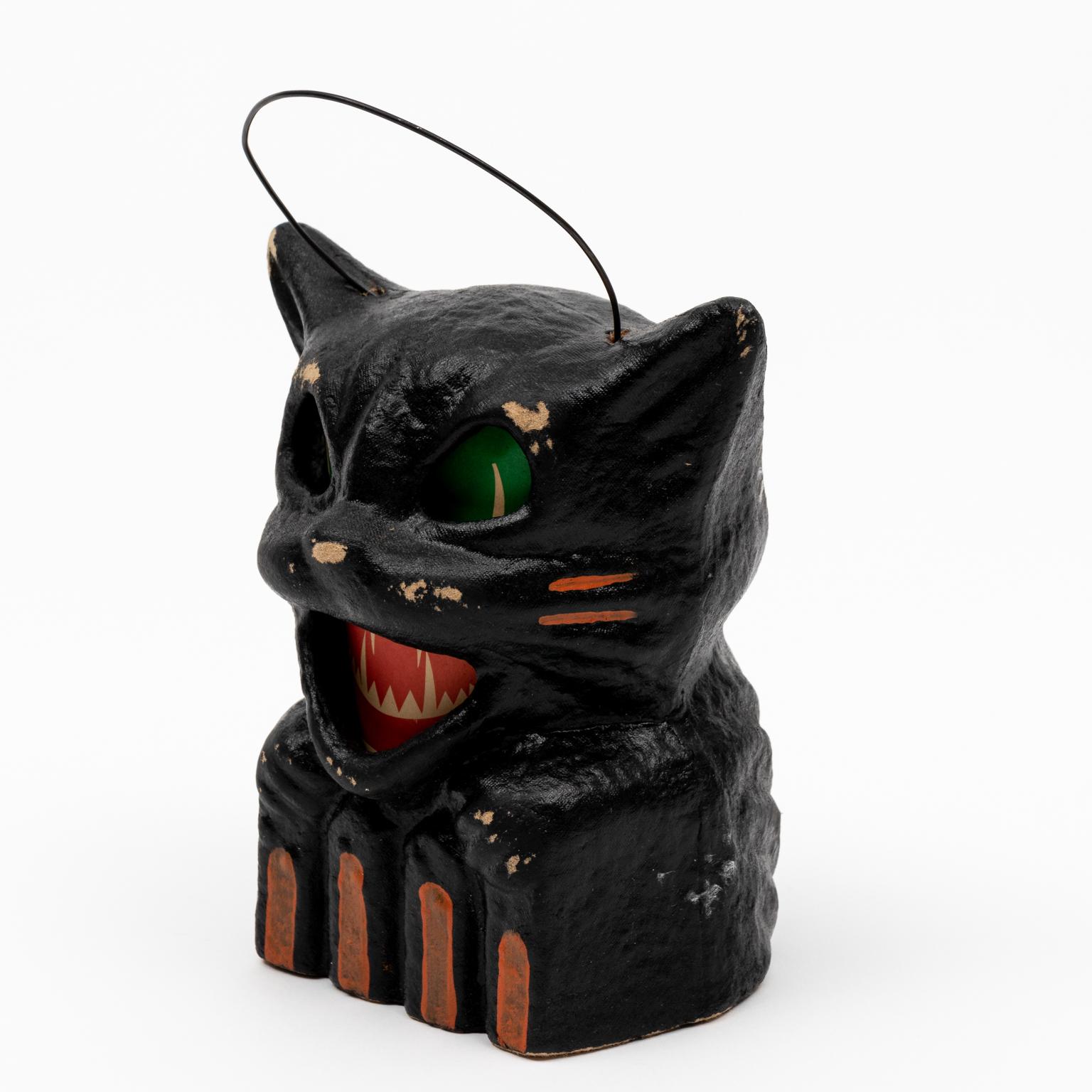 Circa 20th century Halloween themed paper mâché black cat lantern with paper insert. On the bottom of the cat it reads 