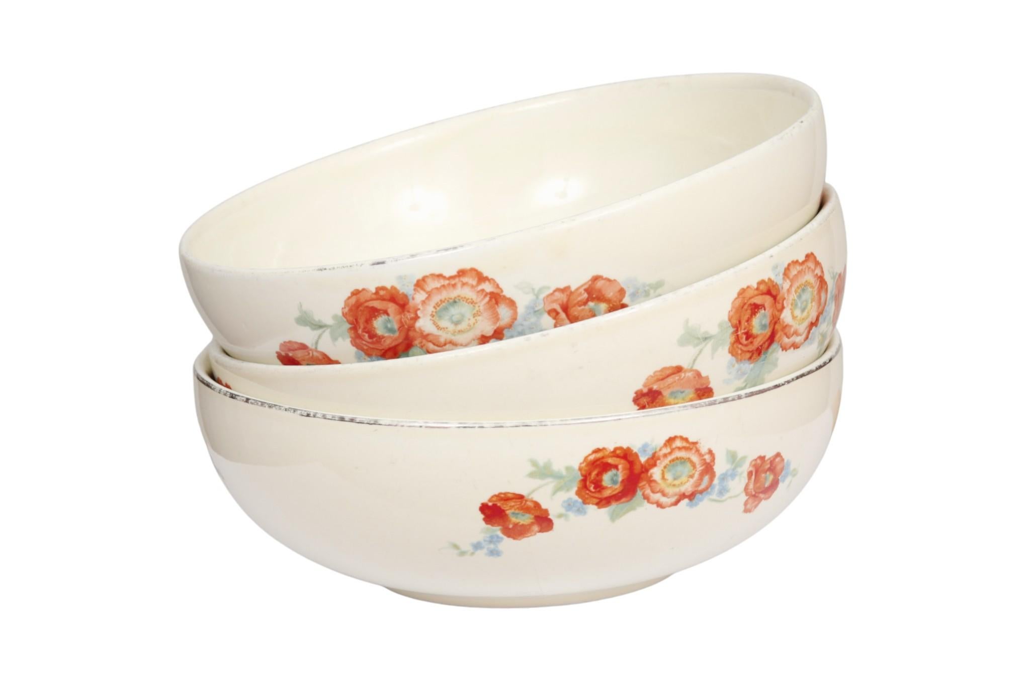 A set of three 1940’s ‘Orange Poppy’ ceramic bowls made by Hall China Company. Each bowl is decorated with a vibrant floral spray of orange poppies, set on an ivory background. Marked underneath “Hall’s Superior Quality Kitchenware, Made in USA”.