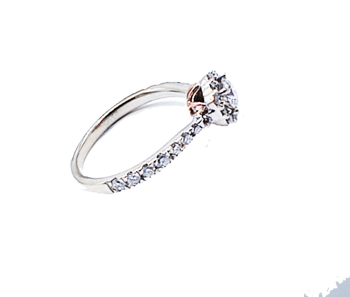 Beautiful Custom-made halo engagement ring is beautifully crafted with an under-cradle pink gold design. The ring measures a 7.30 mm halo and shank that graduates 2 mm from the top to bottom of ring. The height of the halo is 6.03 mm
The ring