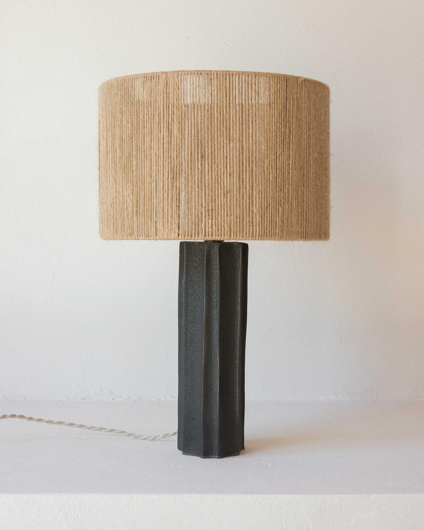 Lampe de table Halo en céramique noire par Grès Éditions
Pièce unique.
Dimensions : Abat-jour : Ø 30 x H 22 cm.
Base : H 30 cm.
MATERIAL : Jute et céramique.
Poids : 2,6 kg.

Système électrique : câble électrique tissé en lin (longueur : 150 cm),