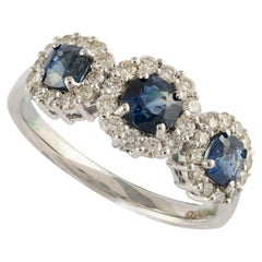 Ring aus 14 Karat massivem Weißgold mit Halo-Diamant und drei Steinen blauem Saphir