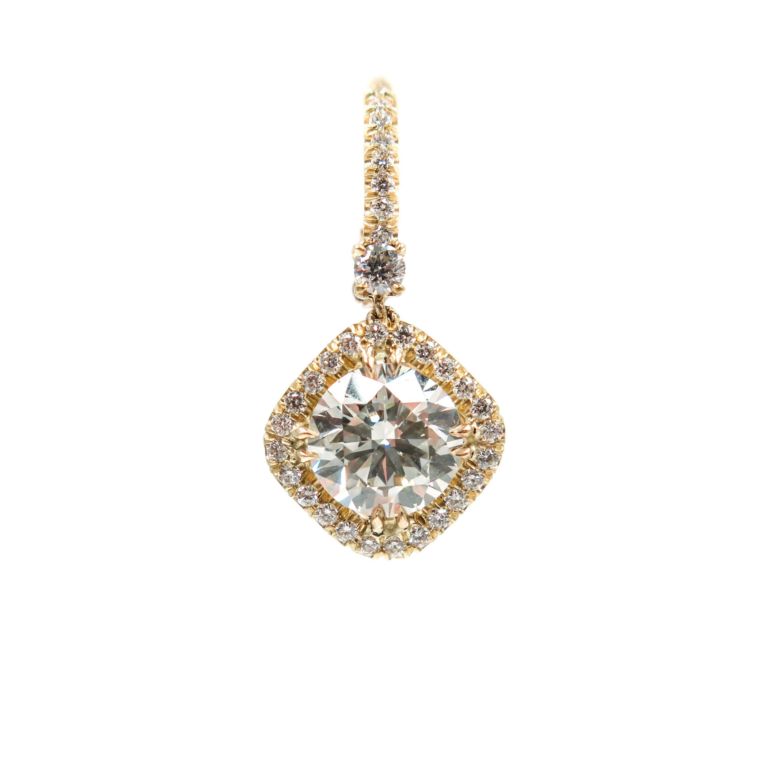 This precious pair of diamond earrings are set in a stunningly handcrafted 18k yellow gold prongs drop with a lever back closure. 
The center round brilliant cut diamonds are J in color, VS2 in clarity and have a respective individual carat weight