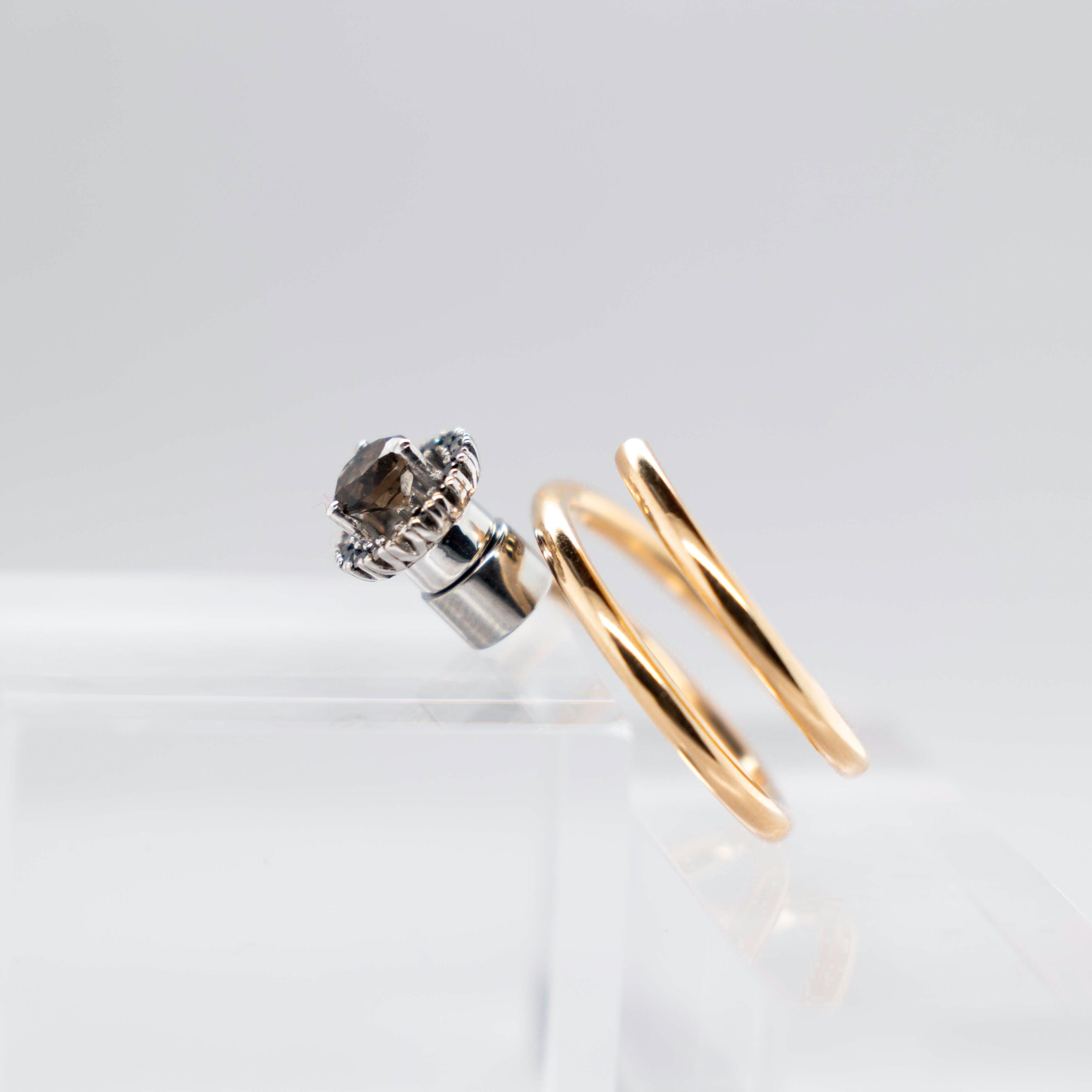 Halo Engagement Ring with Diamonds A (17 units, 1mm Ø) & Smoked Quartz (0.7 ct), brilliant cut in a Head White, 18K 
Elastic Spiral Yellow Gold Ring, 18K

You can put and take on, the Smoked Quartz with Halo of Black Diamonds in White Gold (18K), in
