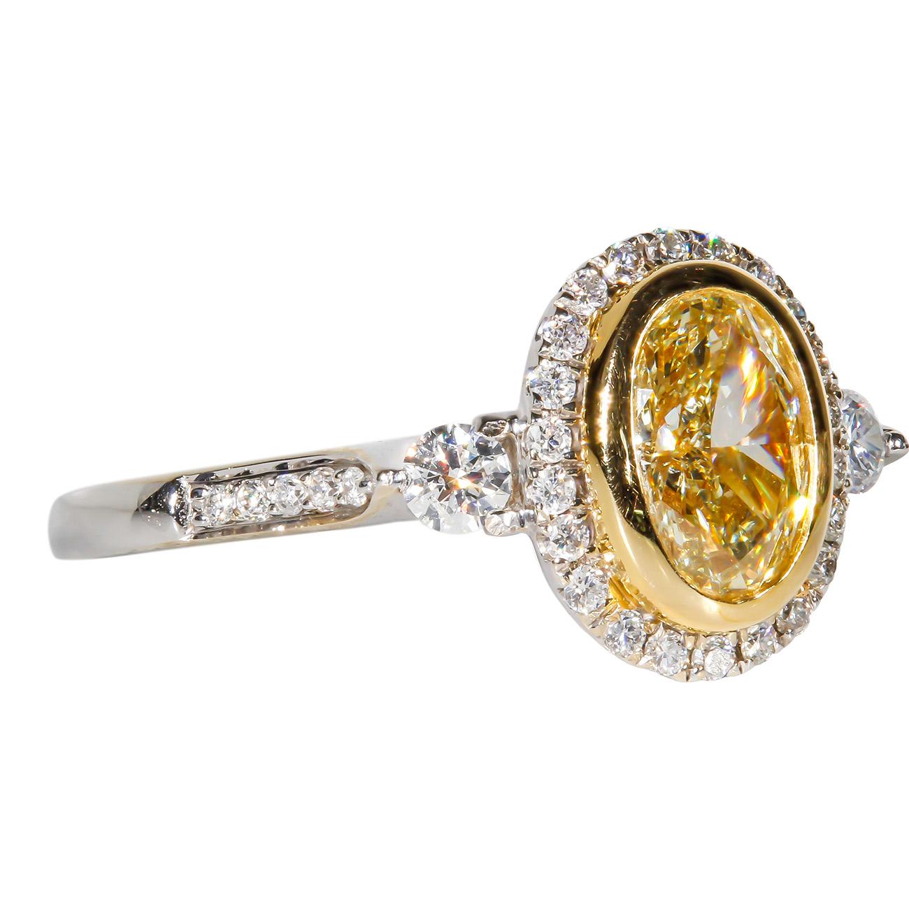 Halo ring in 18K white gold with pre-set rounds and fancy light yellow oval diamond center stone. D1.36ct.t.w. (Center - 1.07ct.)
