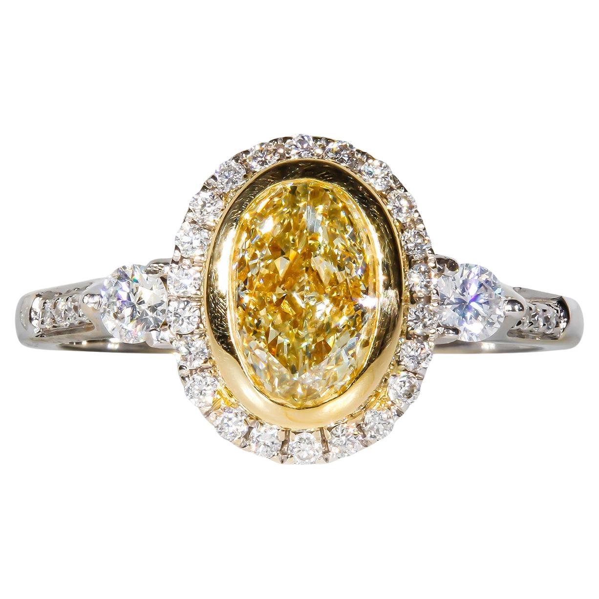 Halo Ring in 18K WG with Fancy Light Yellow Oval Diamond Center. D1.36ct.t.w.