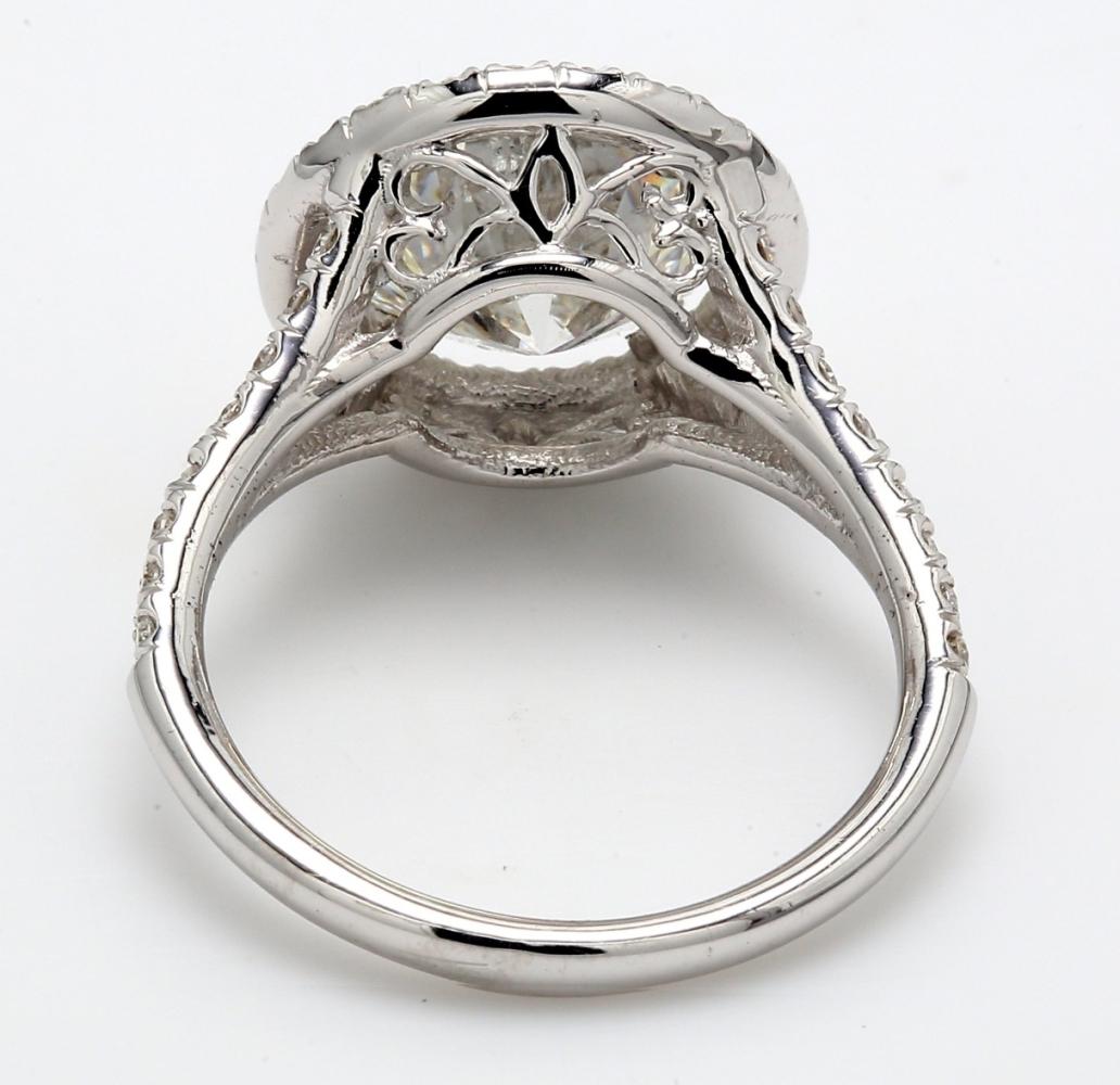 Halo split shank ring in 18K white gold with prong set rounds around GIA certified F/SI2 cushion cut diamond center. D4.60ct.t.w.  (Center - 4.02ct.)