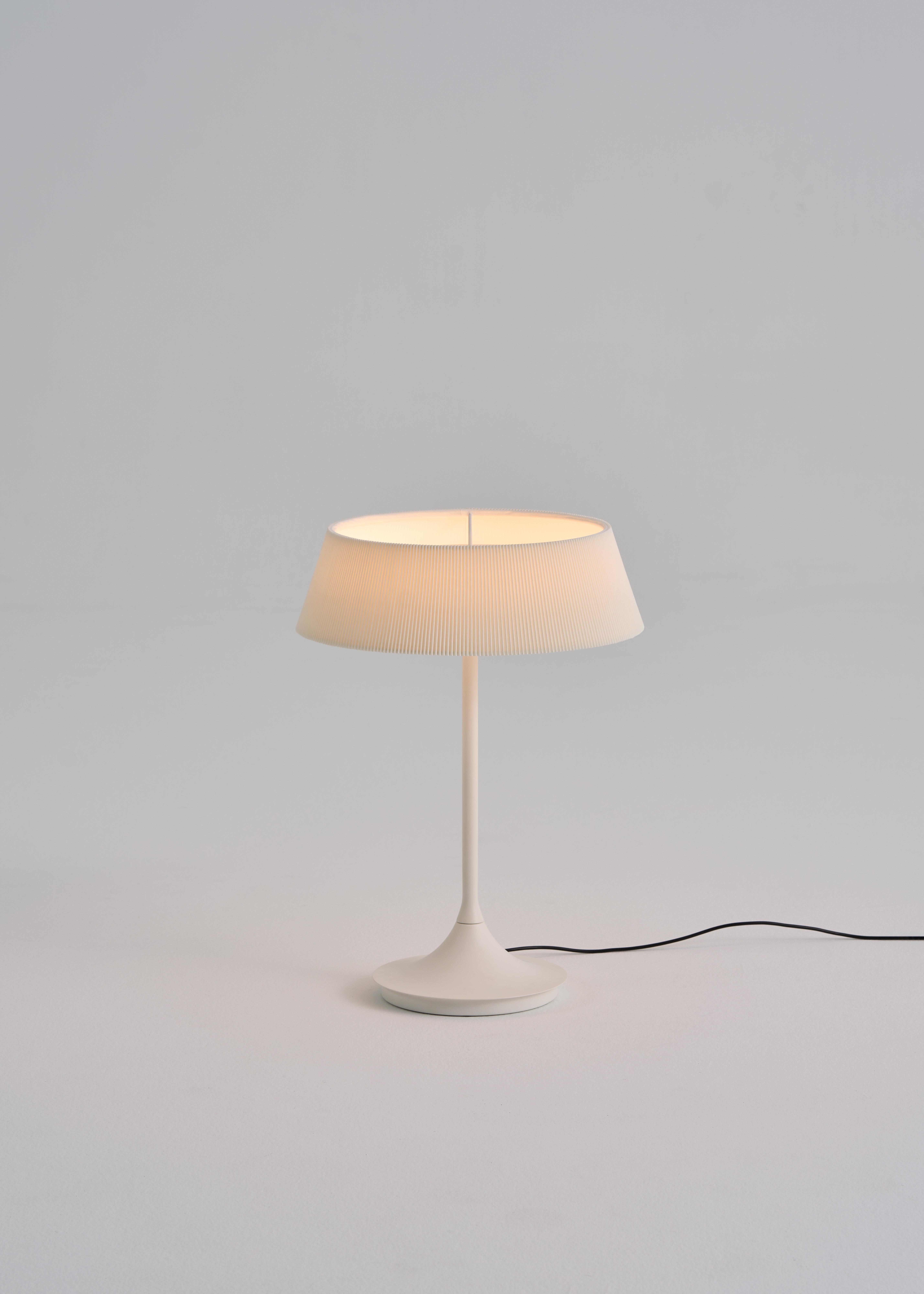 The HALO Table Lamp draws inspiration from the nostalgic charm of classic lighting design. Featuring a built-in LED with high color rendering, it creates a soothing atmosphere that mimics natural sunlight. The finely pleated fabric shade seamlessly