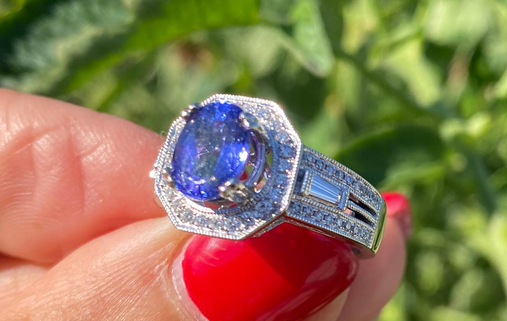 Contemporary, Hexagon Tanzanite and Diamond Ring, VS 2.70 TCW, 18 KT
Center oval shaped Tanzanite measuring 8.40 x 7 mm with a weight of 1.90 carat.
Hexagon style setting of halo diamond bezel accents round and princess cut diamonds
The weight of