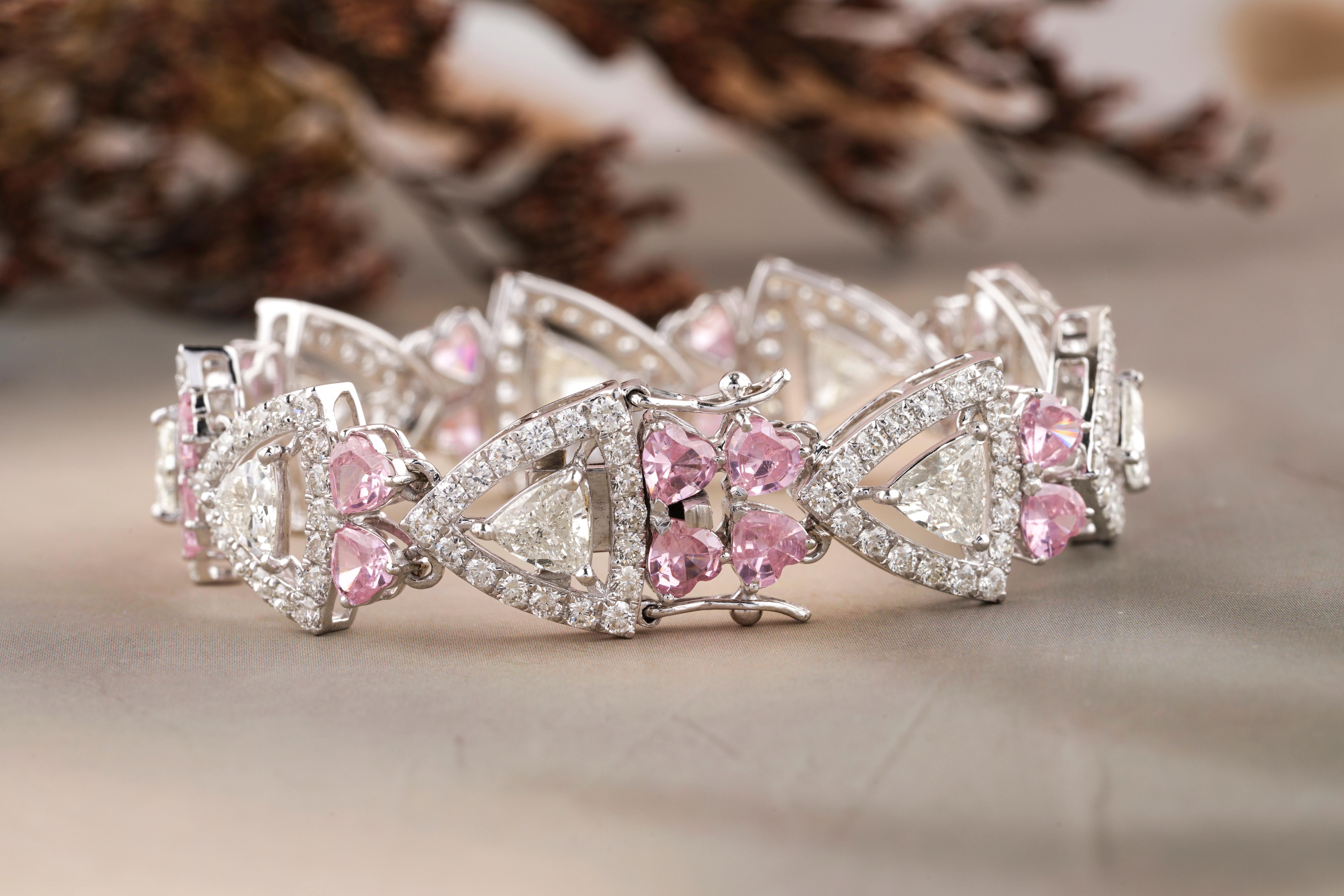 This diamond and pink tourmaline bracelet is a breathtaking piece of jewelry that combines the timeless beauty of diamonds with the vibrant and feminine charm of pink tourmaline. This piece features trillion & round cut diamonds with heart-shaped