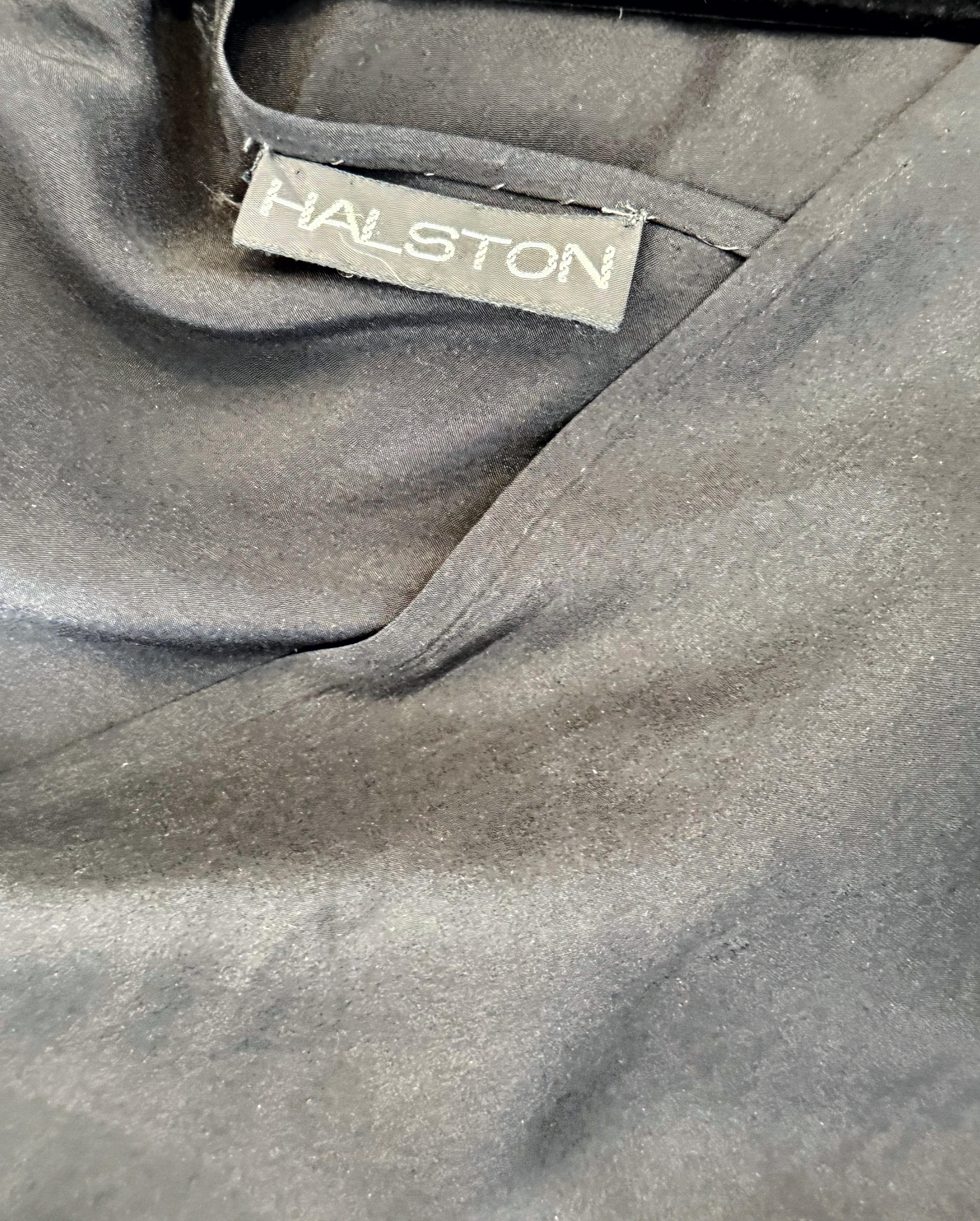 ¡Precioso e icónico vestido negro de corte al bies Halston vintage de los años 70! Presenta un escote asimétrico delante y detrás. Simplemente se desliza sobre la cabeza. Botones en cada puño de las mangas obispo. El movimiento de esta pieza cuando