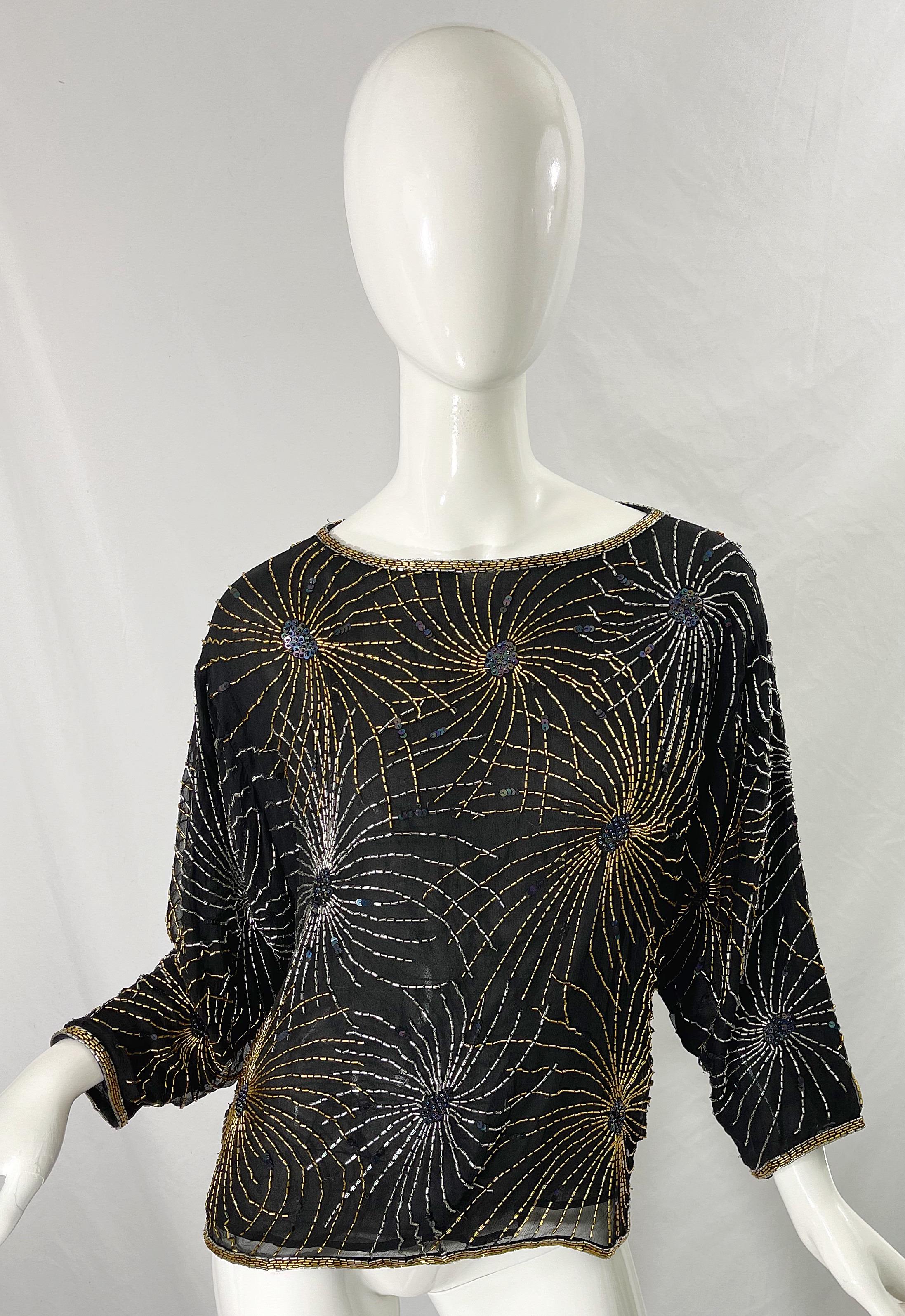 Beautiful iconic late 70s HALSTON black silk chiffon fireworks disco top shirt ! Features thousands of hand-sedan silver and gold sequins with iridescent sequins scattered throughout. Slight dolman sleeves make this accessible to an array of bust