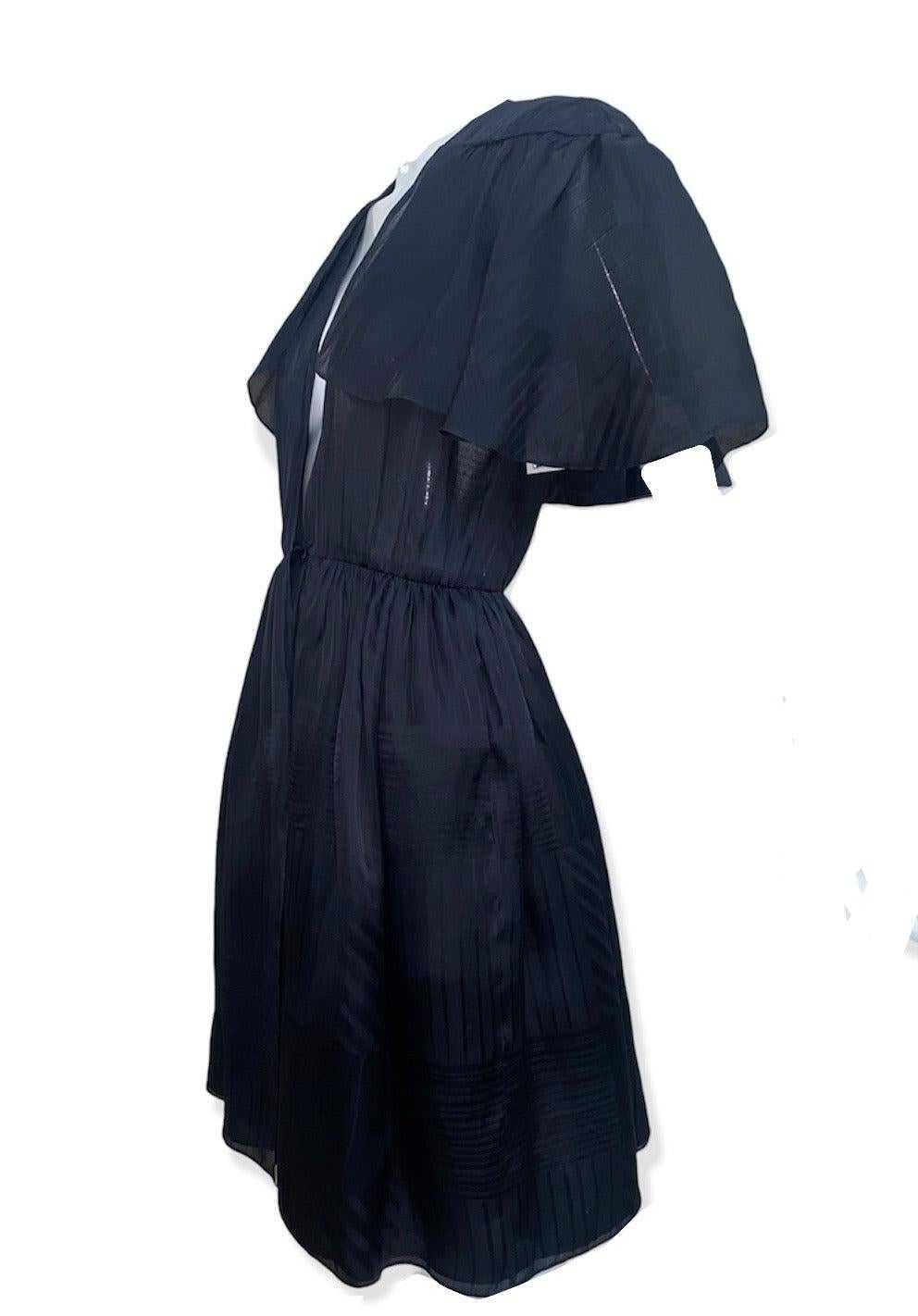 Halston de finales de los 70. Un vestido negro de tafetán de seda jacquard de estilo envolvente. Medio forrado (la mitad inferior porque los pezones eran accesorios brillantes en la época de la música disco). Cierre de doble gancho en la cintura.