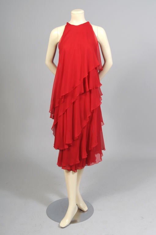 Layers and layers of ruffled red silk chiffon are used in this striking and sexy evening dress from Halston. It slips on over your head with hooks and eyes at each shoulder seam.  The dress is in pristine condition.
Measurements;
Bust 34