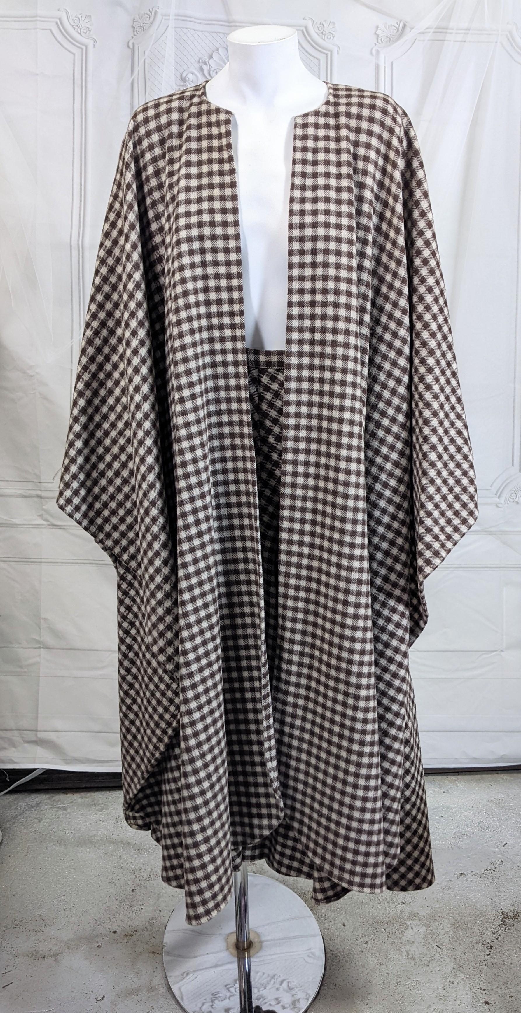 Elegant Halston Checked Wool Cape Skirt Ensemble composed of open cape and long flared skirt in a brown/beige check. Cape is simply cut with front slash opening. Bias skirt is ingeniously cut in a flared silhouette with the seaming creating fullness