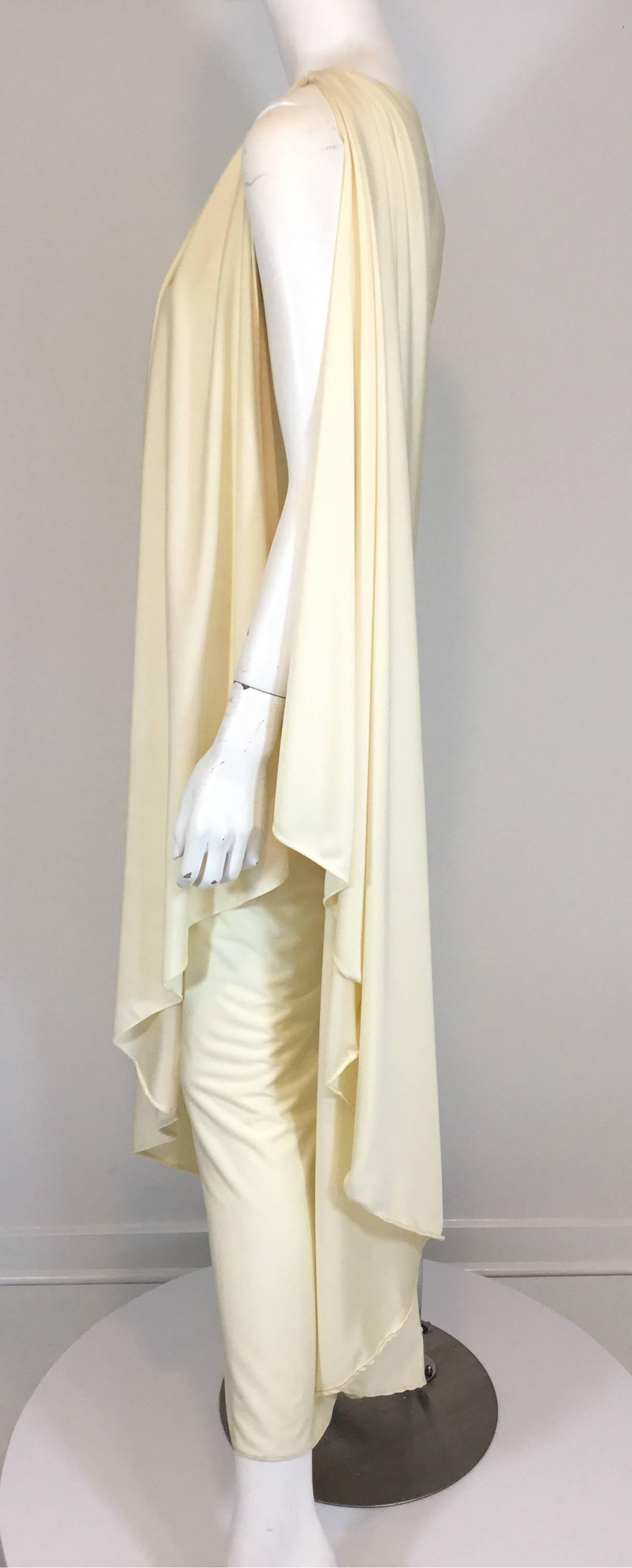 Halston IV one shoulder gown in an ivory/off-white synthetic jersey fabric. Has a hook-and-eye closure at the shoulder. Celebrity favorite and looks very good on.

Measurements: bust 33'', waist 36'', hips 38'', length 52''
