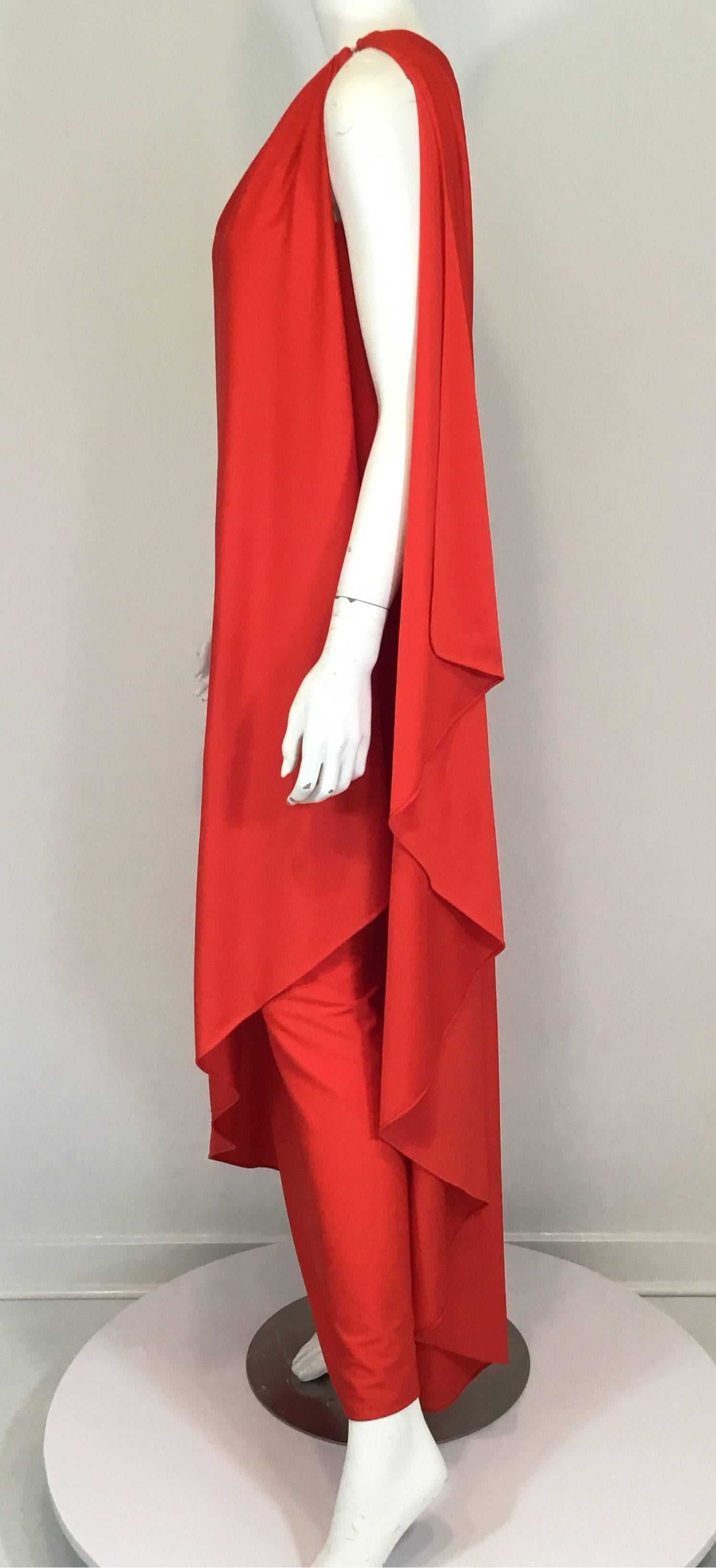 Halston IV 1970s one shoulder gown in a red-orange jersey fabric. Features a hook-and-eye closure at the shoulder ins a side slit at the bottom side. Very attractive on. Fabric is a synthetic. Travels well.

Measurements: bust 34'', waist 38'', hips