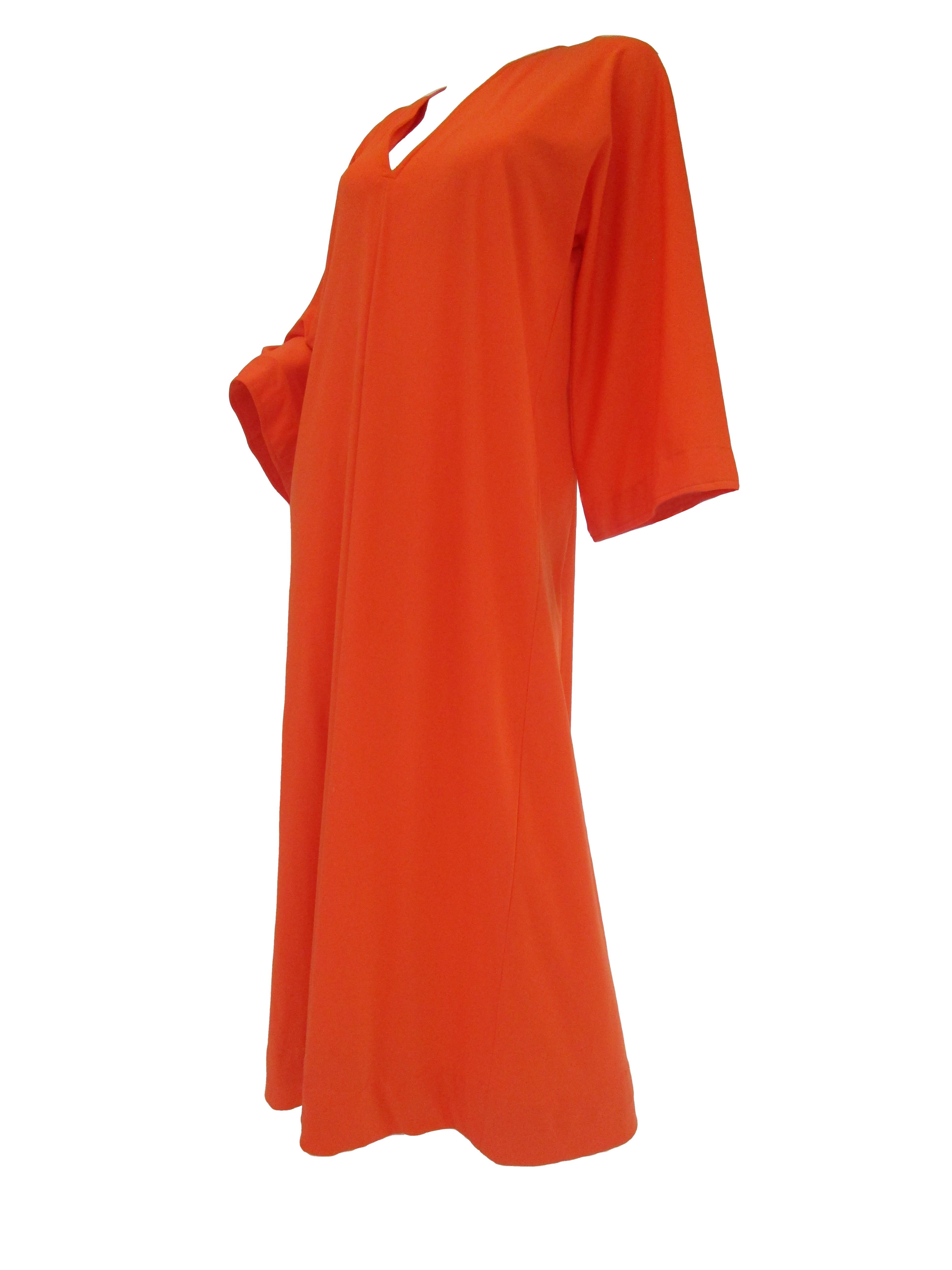 Check out this comfortably stylish orange jersey knit kaftan from Halston IV. 

This kaftan maintains his iconic minimalist design with its easy fit, long sleeves that widen towards the wrist, and its deep V neck that is empirical of many Halston