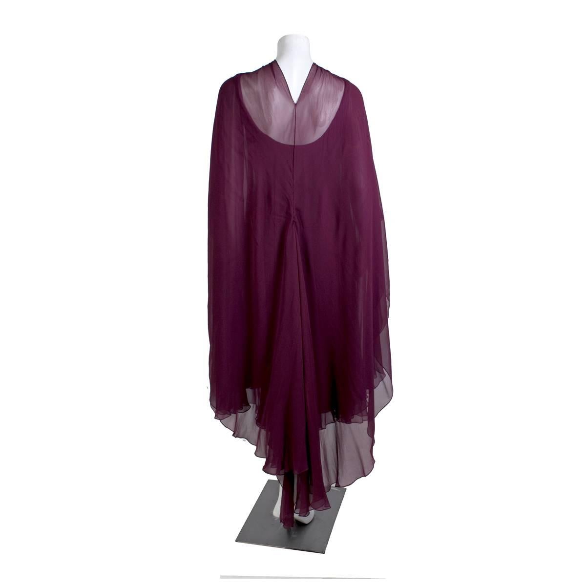 Dress by Halston circa 1970s
Scoop neck dress with sheer sleeves and layers of goddess draped purple silk 
Includes a matching sheer silk cover that can tie at neck as a cape
Condition:  Excellent vintage condition
Size/Measurements:
36