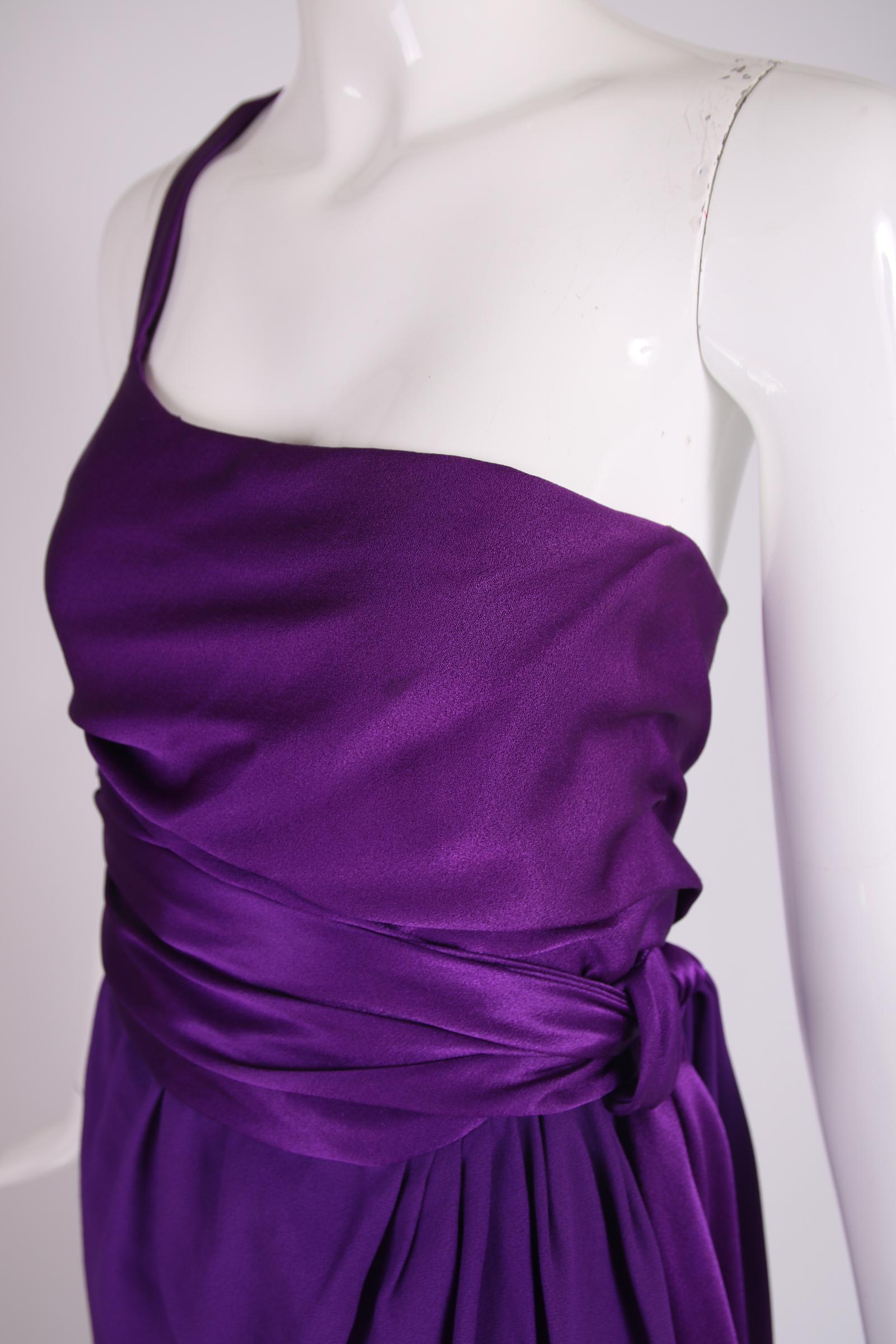 1970's Halston purple silk evening gown with a single shoulder strap and wrap skirt featuring a draped waist tie. The silk fabric which the bodice and waist tie are fabricated from is shiny silk satin while the skirt fabric is either a silk crepe de