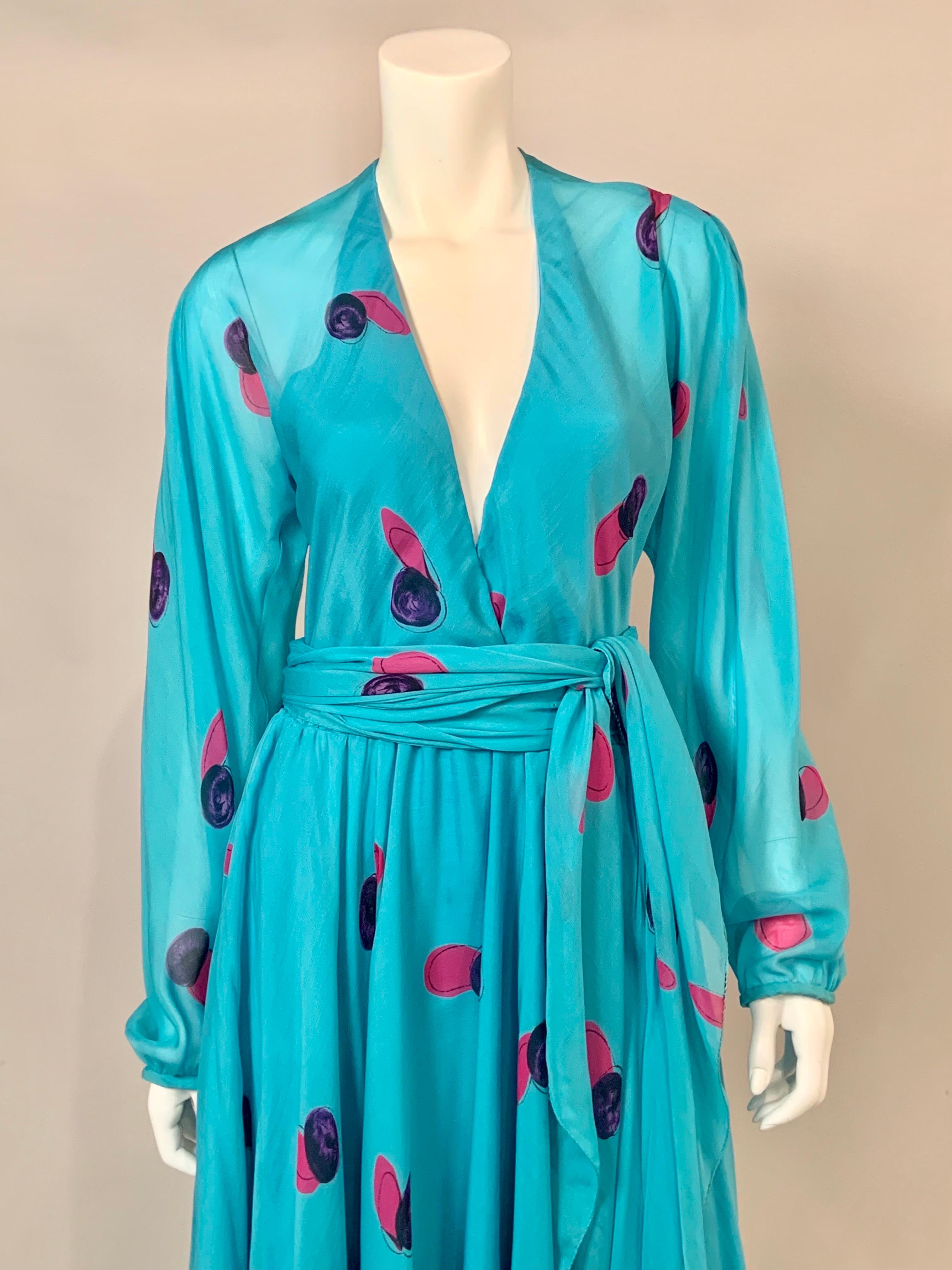 A gorgeous turquoise blue silk chiffon from Halston is printed with circular designs in magenta and purple.  The dress has a low V shaped neckline, long sleeves, a flowing skirt and a long matching sash belt.  The bodice is lined in the front and