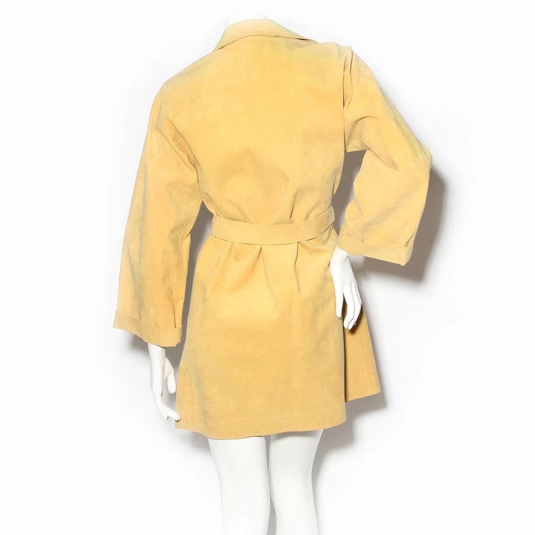 Halston Trench Coat 
Circa 1970's 
Vintage 
Iconic Halston ultrasuede 
Mustard yellow 
Short trench style coat 
Angled slash pockets on each side 
Matching belt around waist 
Notched lapel 
Fold over cuff sleeve 
Unlined 
Excellent vintage