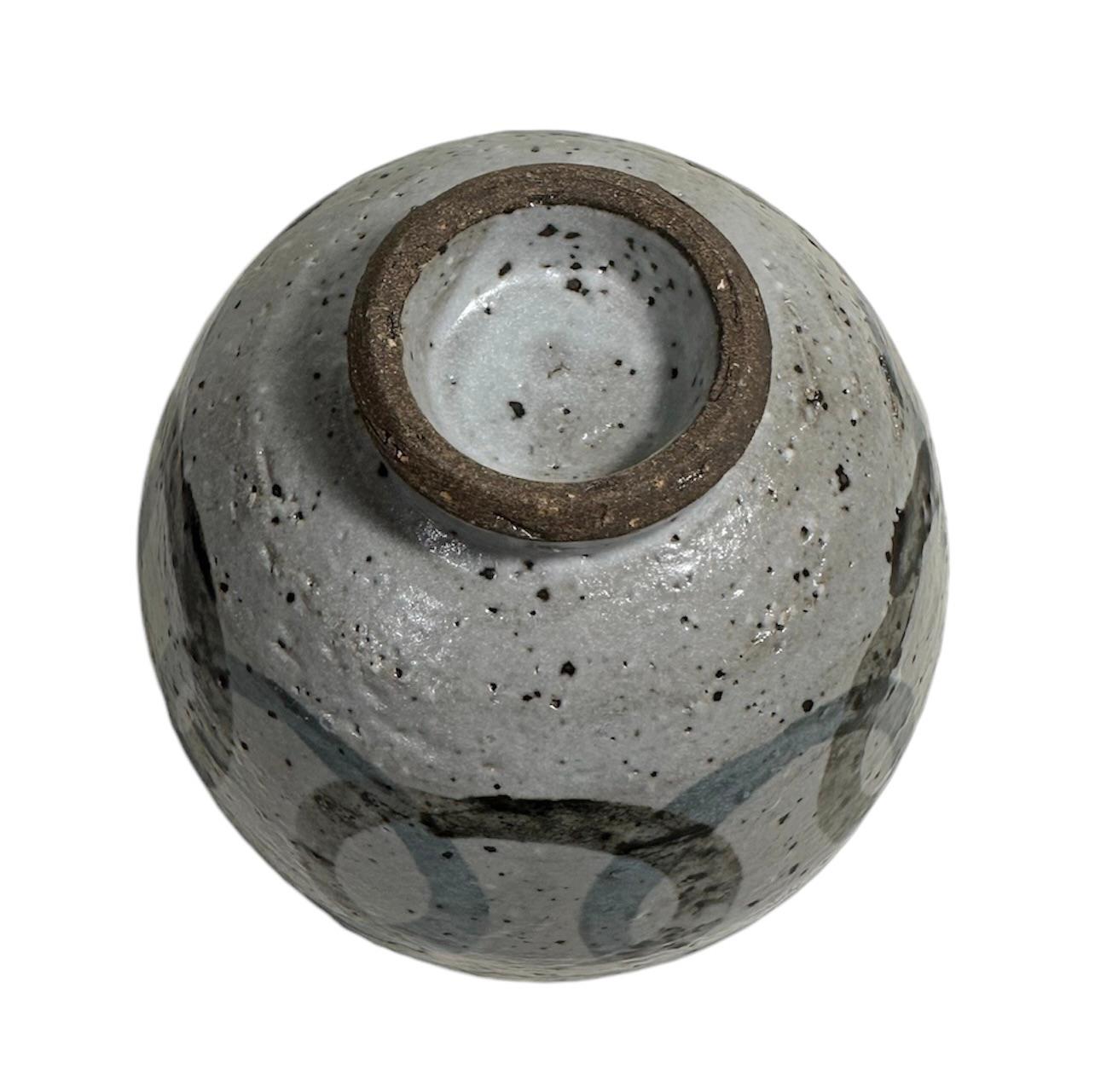 HAMADA SHOJI, (Tokio 1894 - Mashiko 1978)
Enso Teetasse, um 1970
Ton und natürliche Emaille, auf einer Drehbank bearbeitet (H 90 mm x Ø 135 mm). 
Mashiko Chawan Teetasse, mit Gosumarumon überlappenden Kreisen dekoriert.
Die Brenntemperatur beträgt