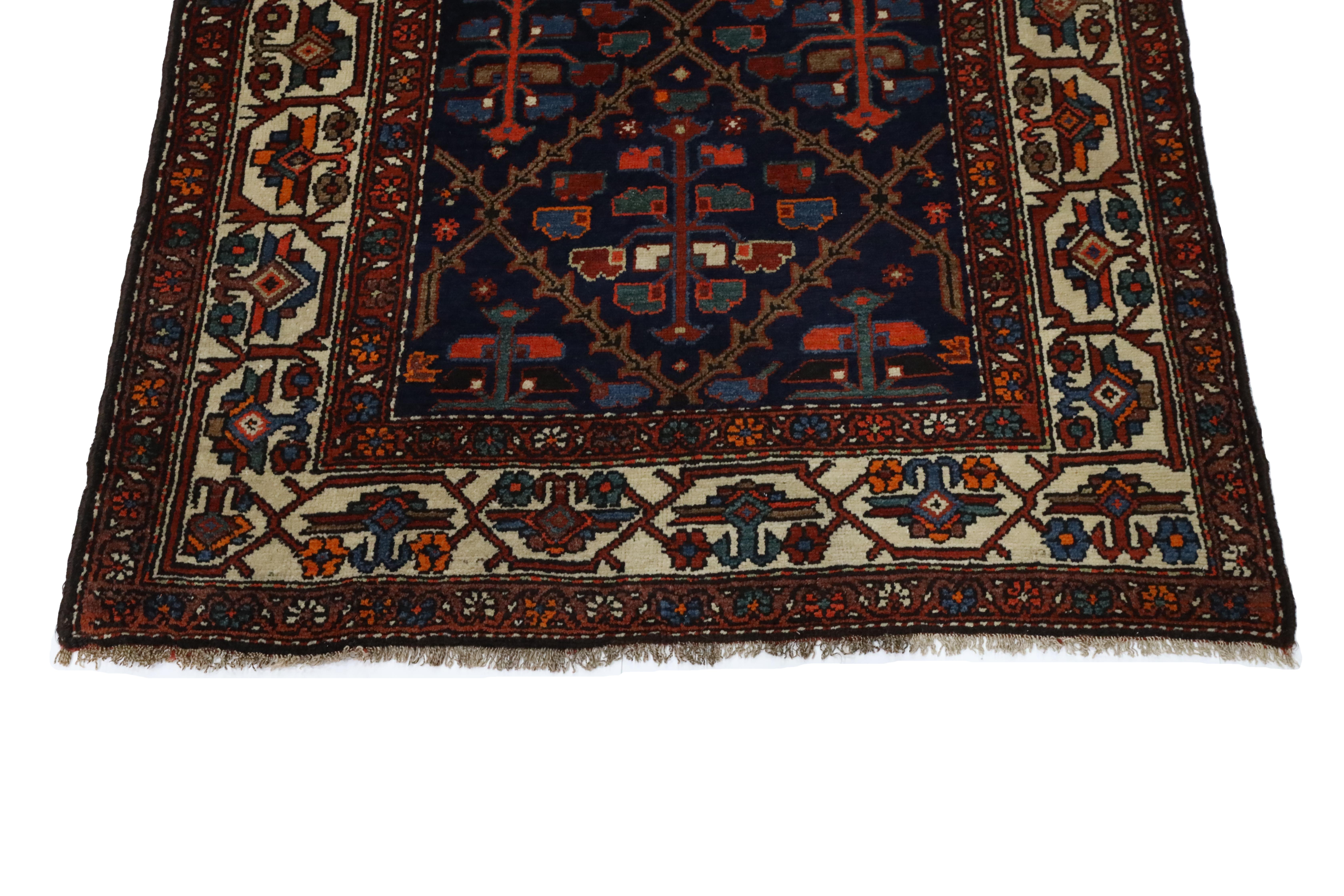 This captivating Hamedan rug is a striking example of Persian craftsmanship, with a distinctive all-over geometric design set against a deep, rich navy background. The rug's design is built around a cross-pattern that creates intricate diamond