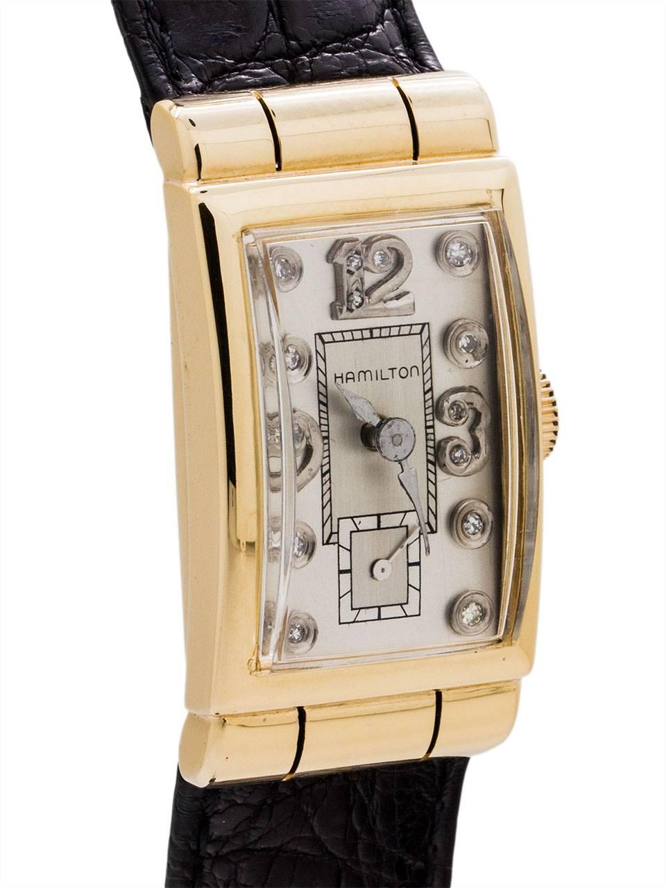 
Vintage Hamilton14K YG hooded case diamond set “tuxedo” model circa 1950’s. Featuring a 21 x 40mm rectangular curved style case with with “fluted” hoods design at top and bottom. With beautifully restored 2 tone silver satin dial with applied
