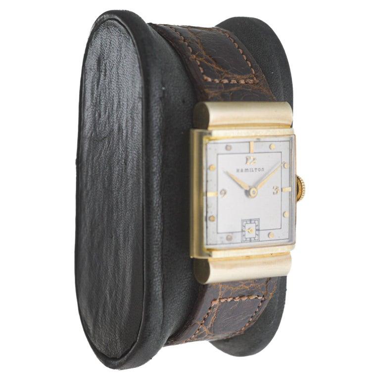 FACTORY / HOUSE: Hamilton Watch Company
STYLE / REFERENCE: Midas Series / Art Deco Tank
METAL / MATERIAL: 14Kt Solid Yellow Gold 
CIRCA / YEAR: 1940's
DIMENSIONS / SIZE: Length 22mm X Width 33mm
MOVEMENT / CALIBER: Manual Winding / 19 Jewels /