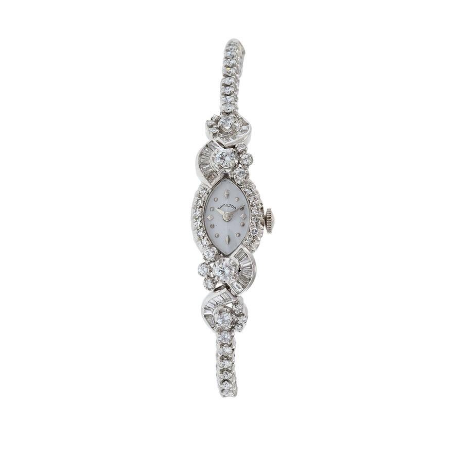 Voici la montre bracelet Hamilton 1950 en or 14kt avec diamants, un mélange étonnant de luxe et d'élégance. Ce garde-temps exquis est doté d'un boîtier de forme marquise et d'un bracelet assorti, tous deux réalisés en or 14kt et ornés d'un