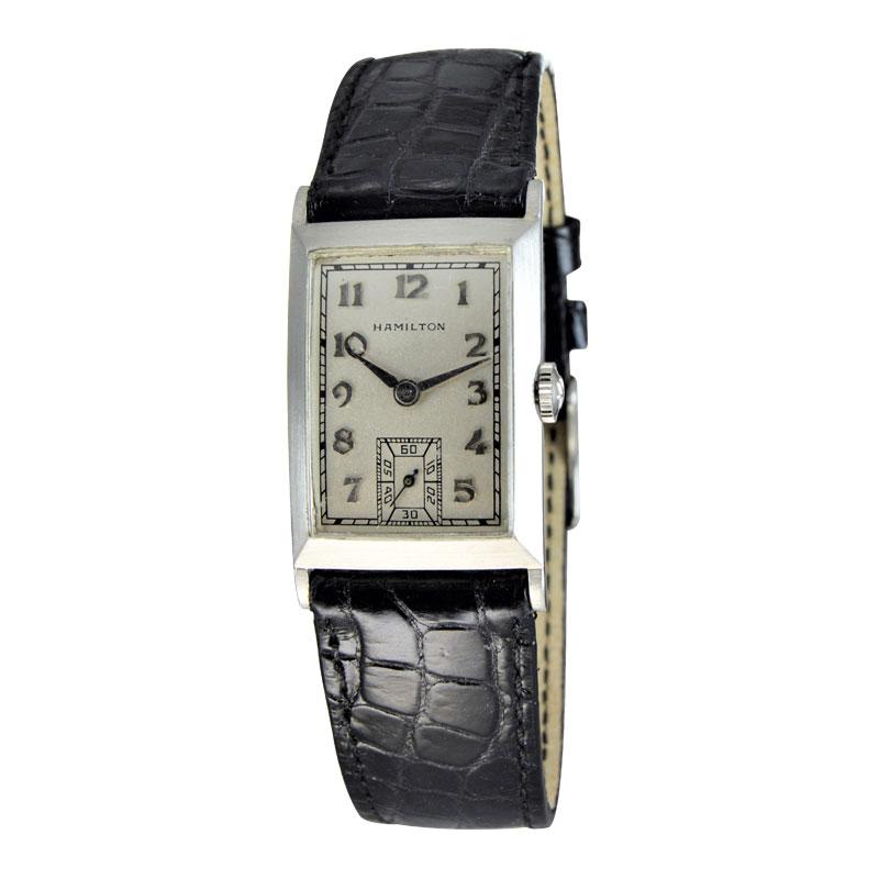 FACTORY / HOUSE: Hamilton Watch Company
STYLE / REFERENCE: Art Deco / Tank Style
METAL / MATERIAL: Platinum
CIRCA / YEAR: 1940's
DIMENSIONS / SIZE: Length 36mm x Width 21mm
MOVEMENT / CALIBER: Manual Winding / 19 Jewels / Medallion Series 
DIAL /