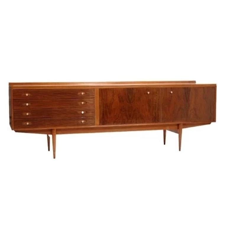 Ce buffet distinctif, fabriqué en bois de rose et en teck, présente quatre tiroirs à façade cannelée. Les doubles portes s'ouvrent pour révéler deux étagères de taille généreuse, étagées et façonnées, offrant un espace de rangement