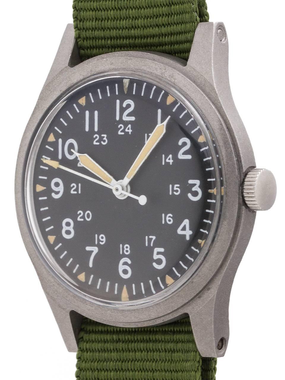 
US Military issue Hamilton man’s wristwatch featuring 34 X 41mm non reflective brushed finish base metal case, acrylic crystal, and original matte black dial with 24 hour indexes and triangular luminous hour indexes, recently re-lumed hands and