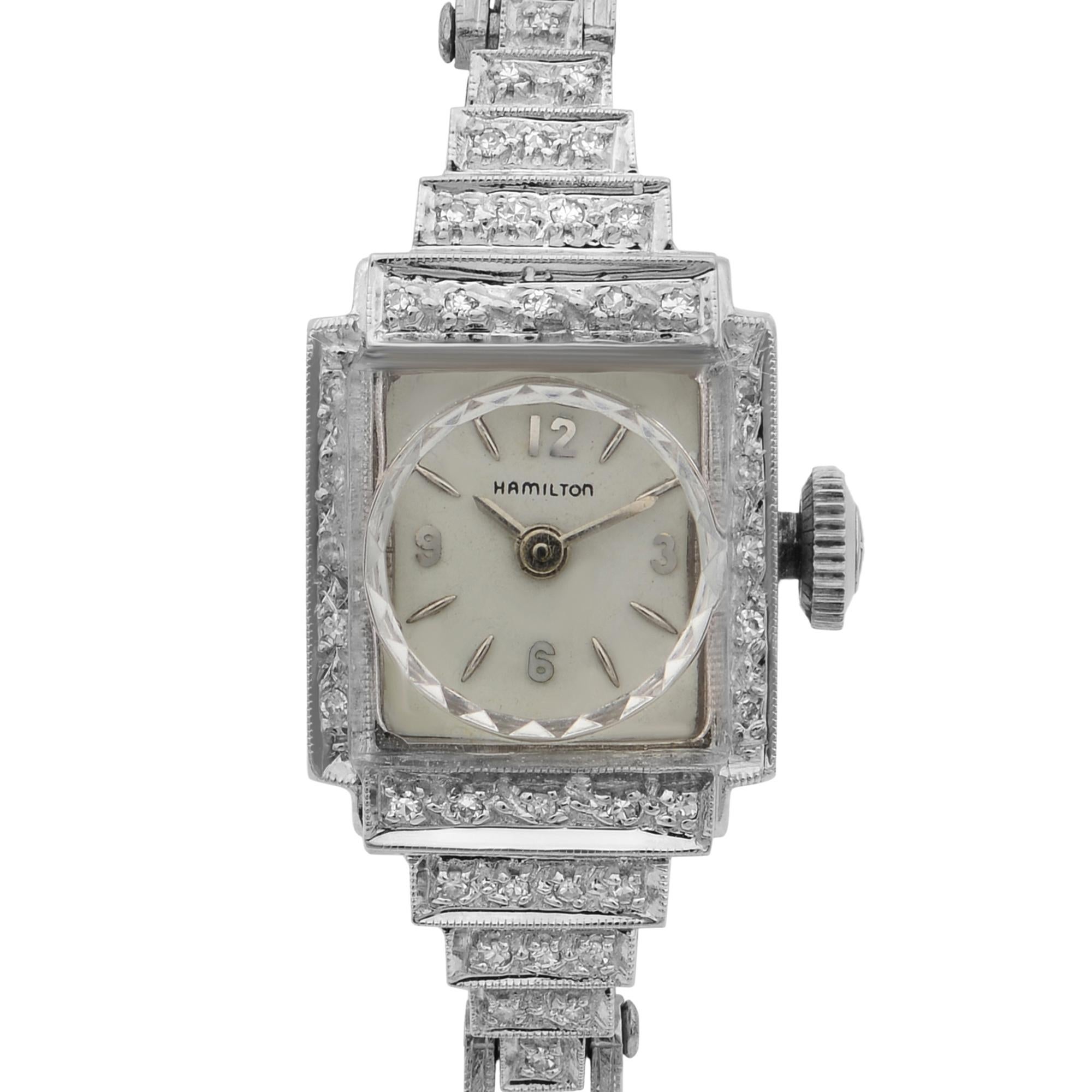 This pre-owned Hamilton Vintage N/A is a beautiful Ladie's timepiece that is powered by quartz (battery) movement which is cased in a white gold case. It has a square shape face, no features dial and has hand sticks & numerals style markers. It is