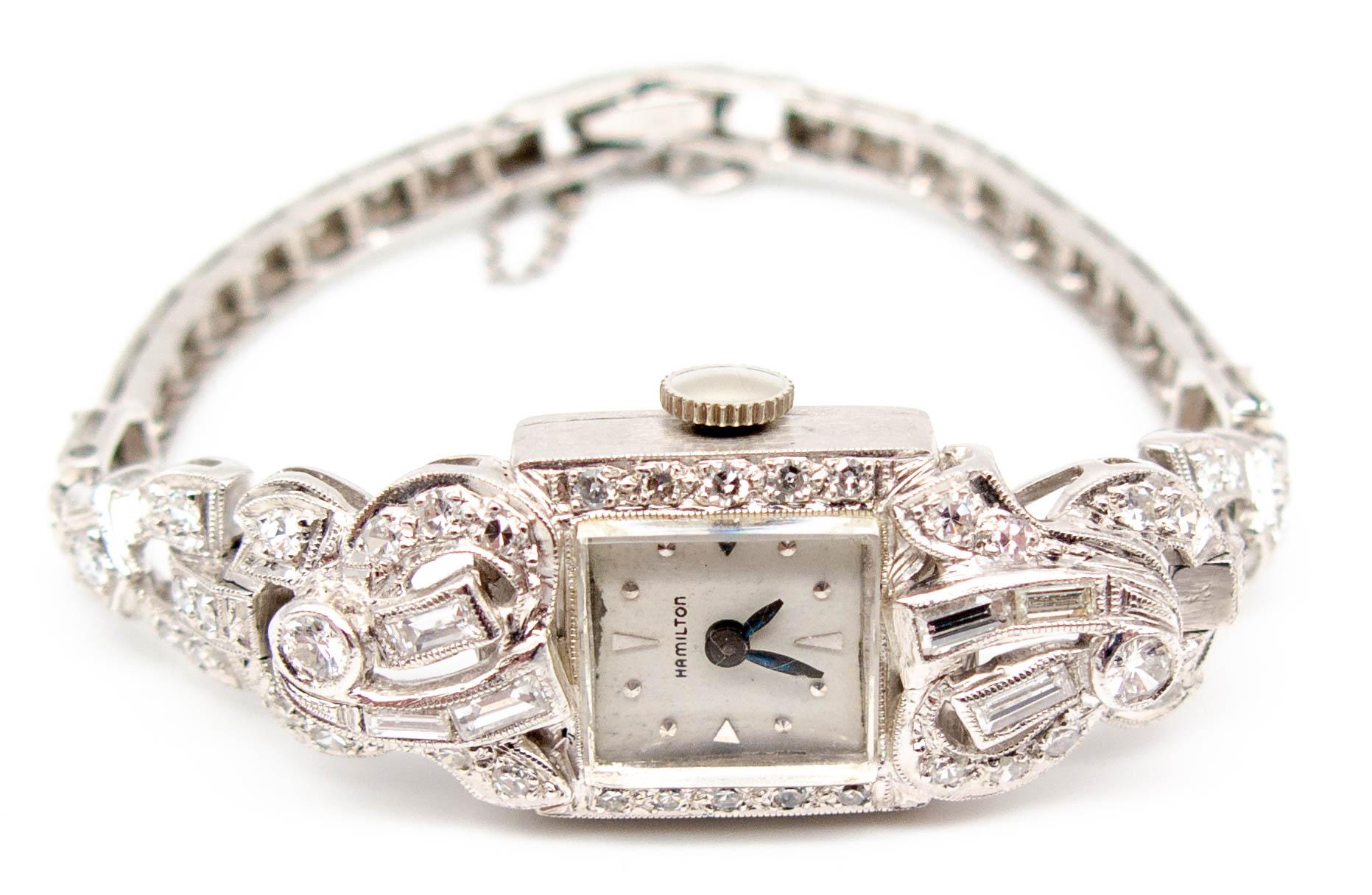 A swirly styled timepiece probably from the 1940's, this Hamilton watch contains a mix of some single cut but mostly modern brilliant cut diamonds totaling about 3 carats.  The watch measures a petite 6 inches in length, is stamped 14 K and has a