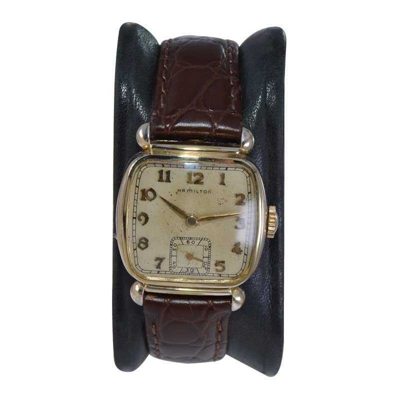 FACTORY / HOUSE: Hamilton Watch Company
STYLE / REFERENCE: Cushion Shape
METAL / MATERIAL: Yellow Gold Filled 
CIRCA / YEAR: 1940's
DIMENSIONS / SIZE: 34mm X 29mm
MOVEMENT / CALIBER: Manual Winding / 17 Jewels / Cal.987A
DIAL / HANDS: Original