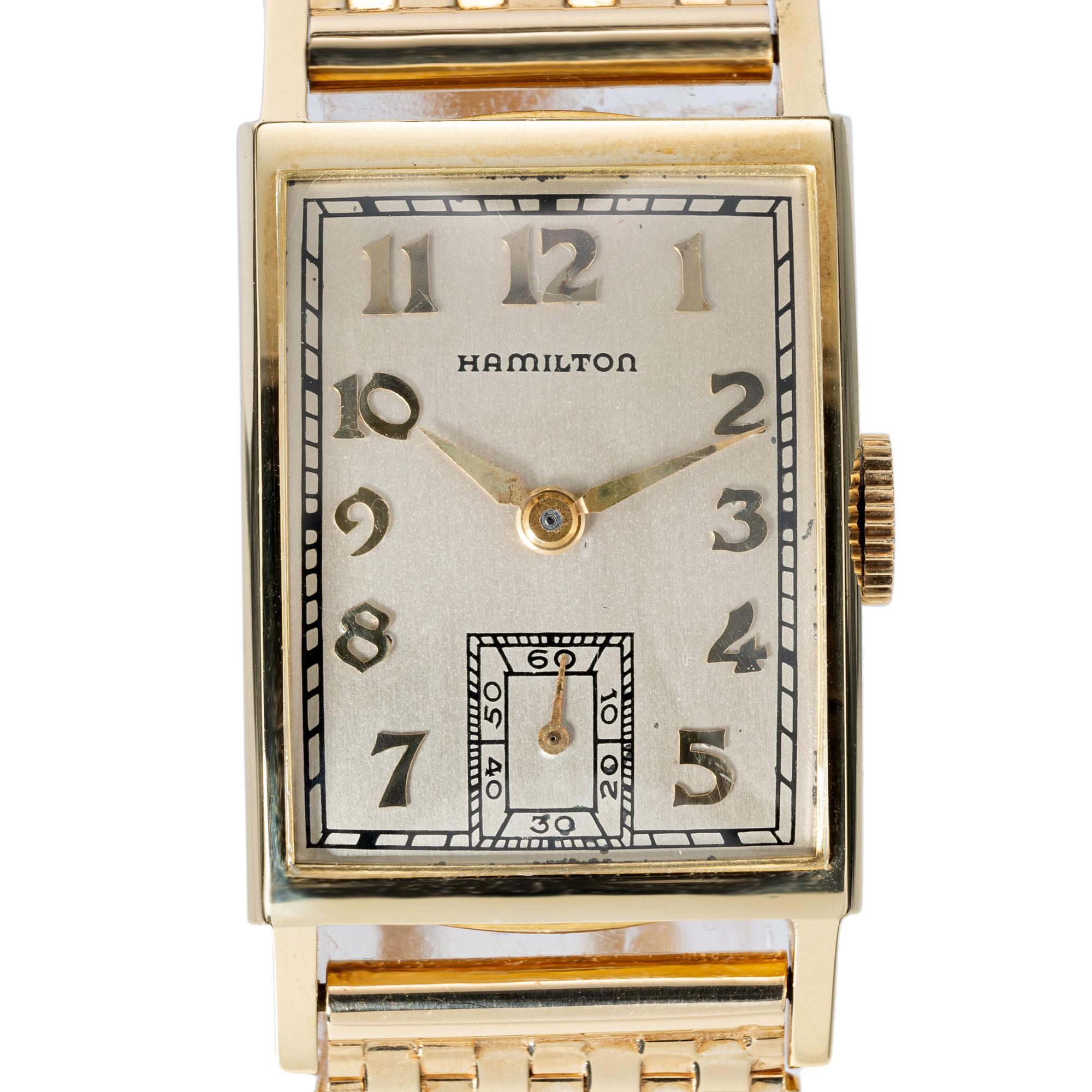 1950's Hamilton 14k yellow gold wristwatch. Rectangle dial with 9 row mesh 14k yellow gold band with a fold over safety buckle. Full one year service warranty. Band length is 6 3/8 inches

Length: 37.36mm
Width: 20.51mm
Band width at case: 16mm
Case